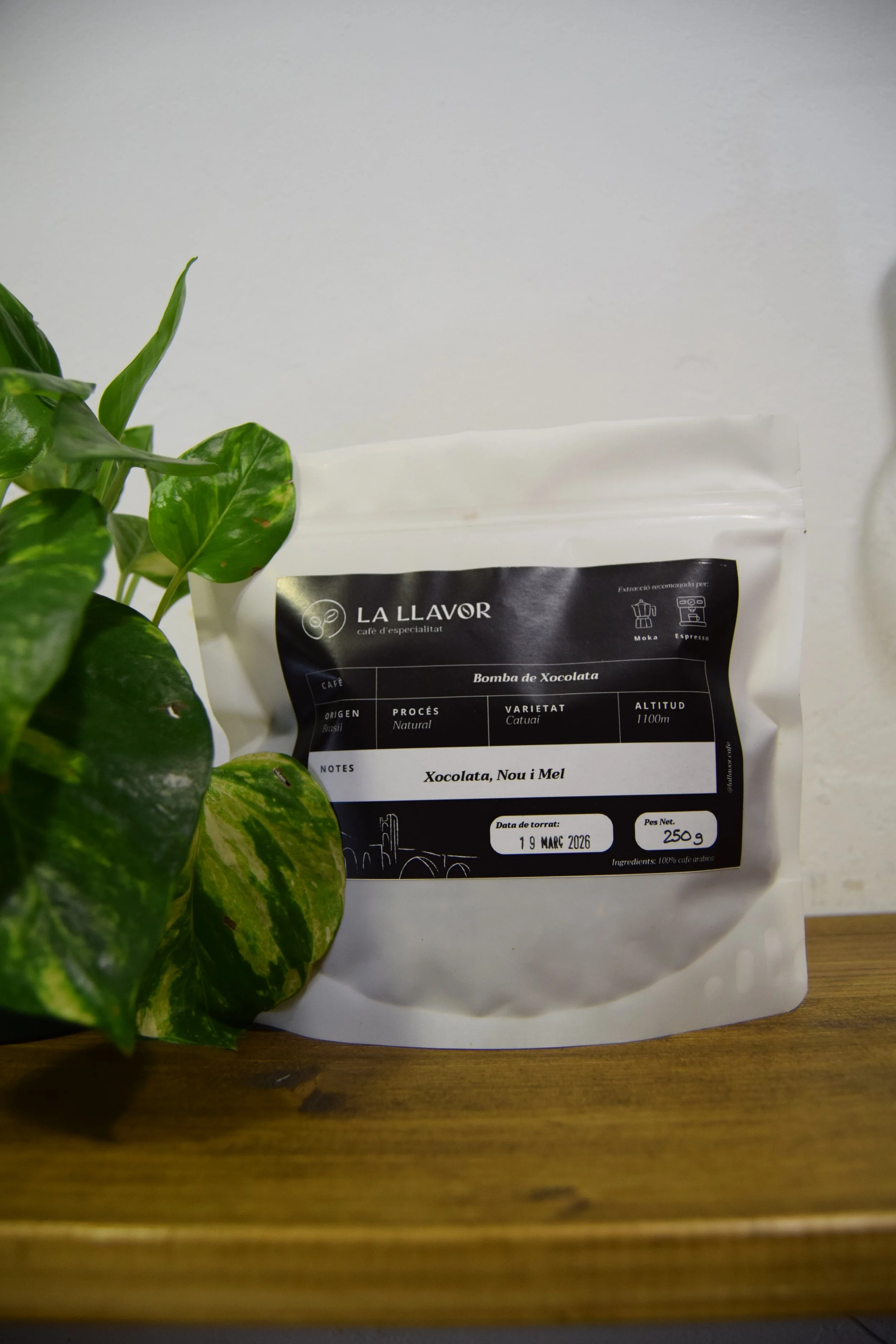 Paquet de cafè de Brasil amb notes de xocolata, nou i mel sobre una taula de fusta