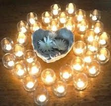 heart bowl with flowers surrounded by lit tea lights