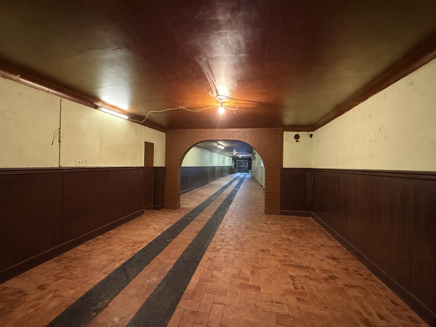Corridor ancien aux lumières tamisées.png