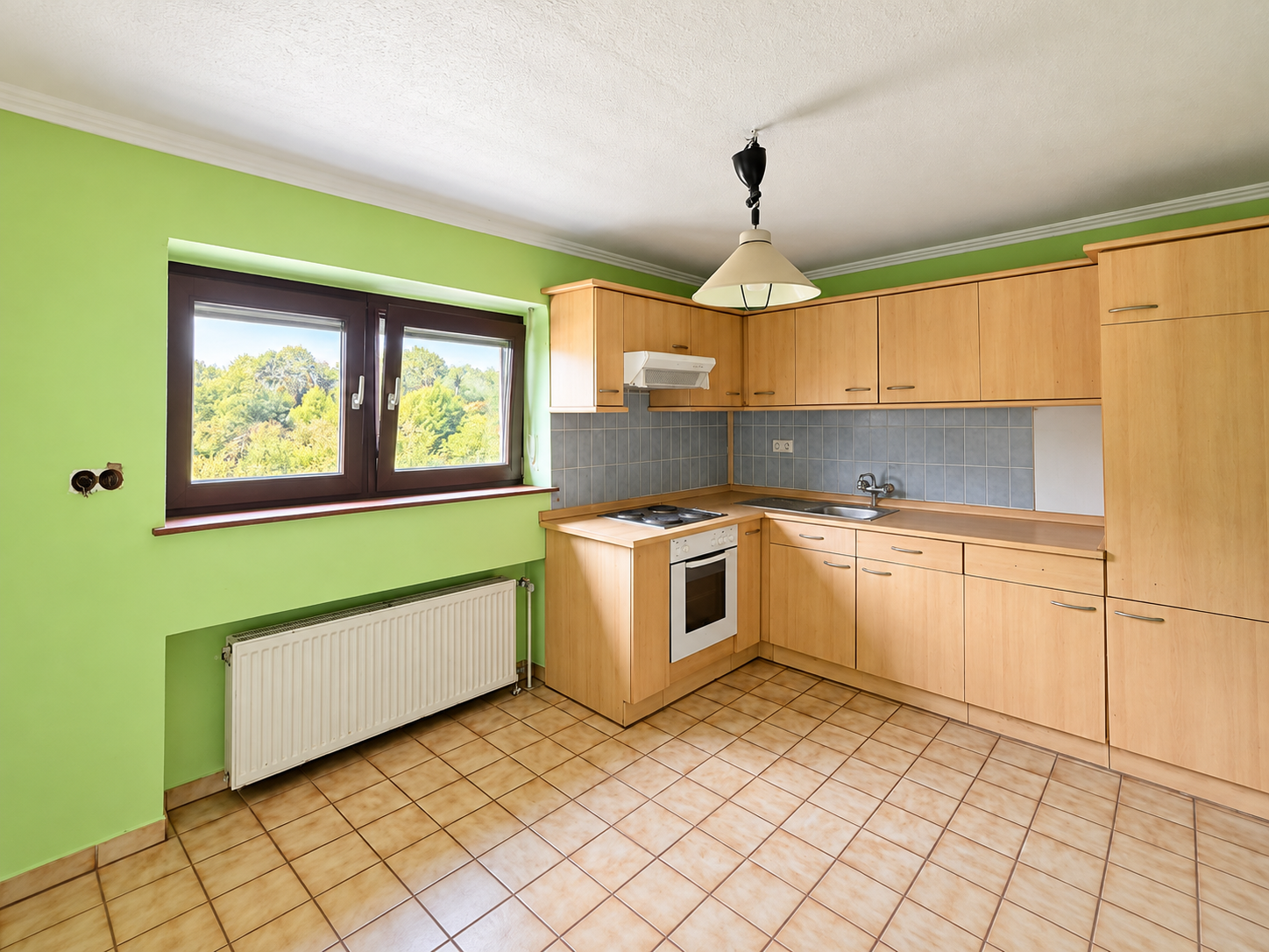 Cuisine en L lumineuse aux murs verts.png