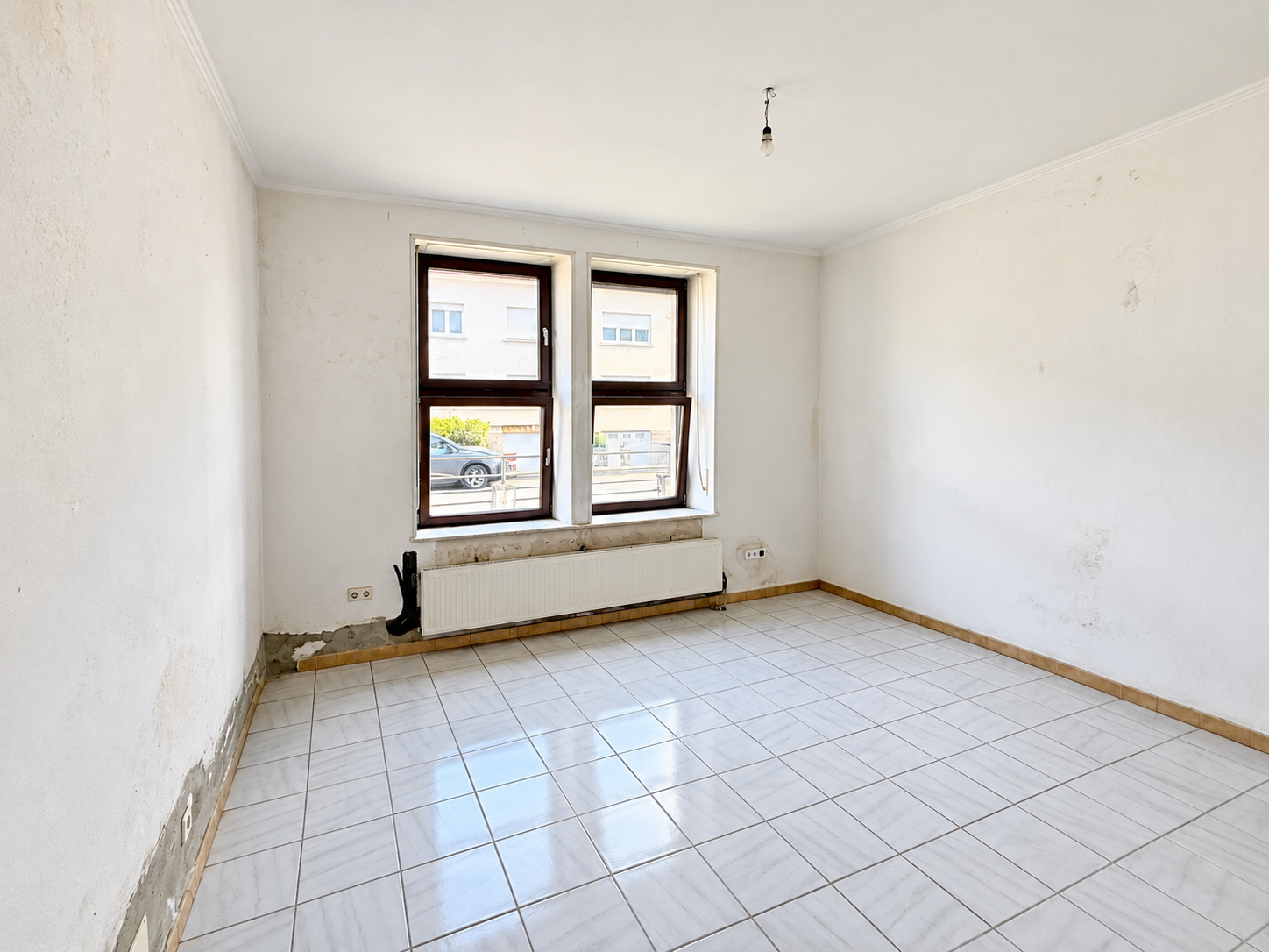 Pièce vide à rénover, fenêtres et radiateur.png