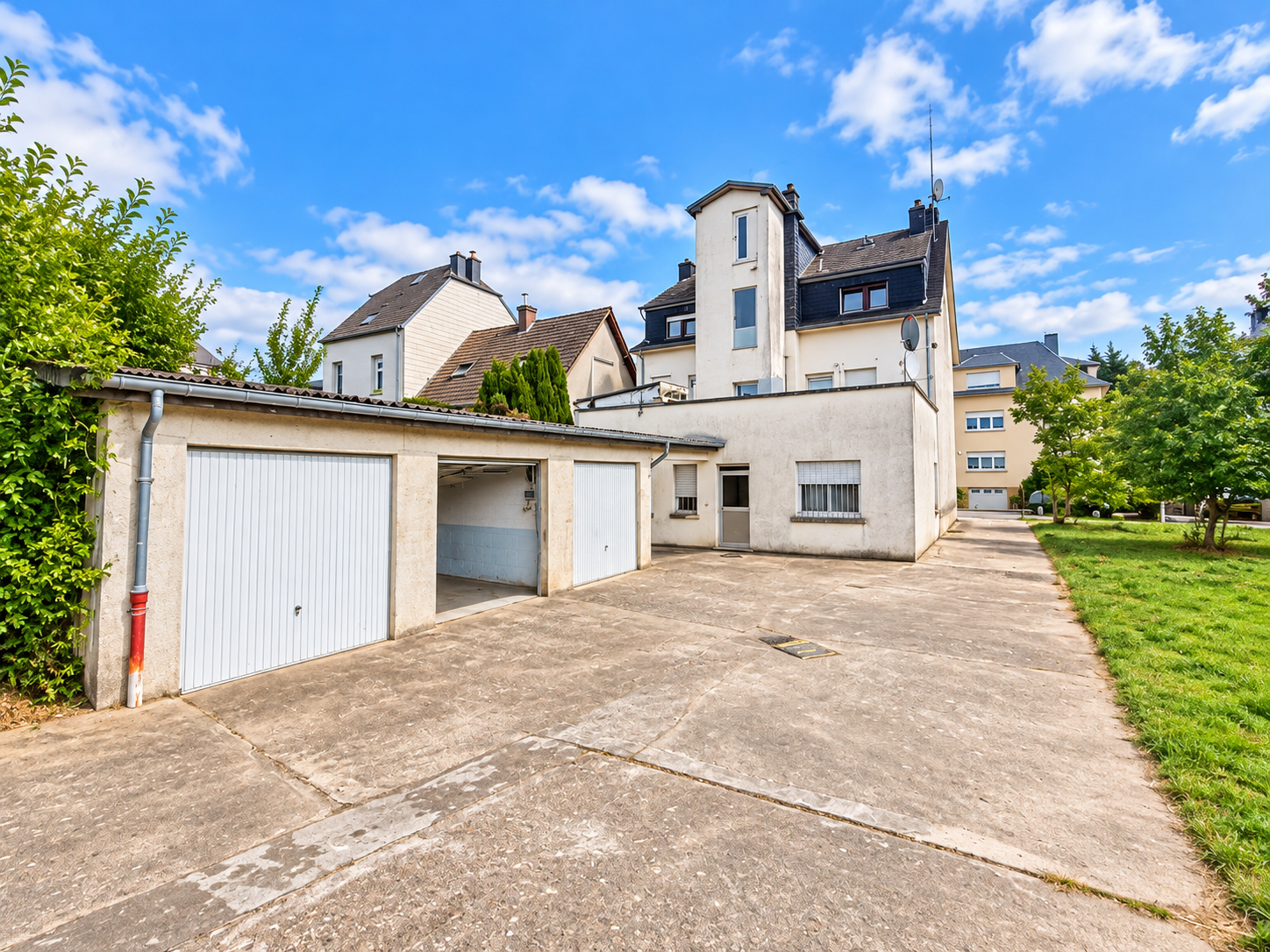 Cour résidentielle et garages sous ciel bleu.png