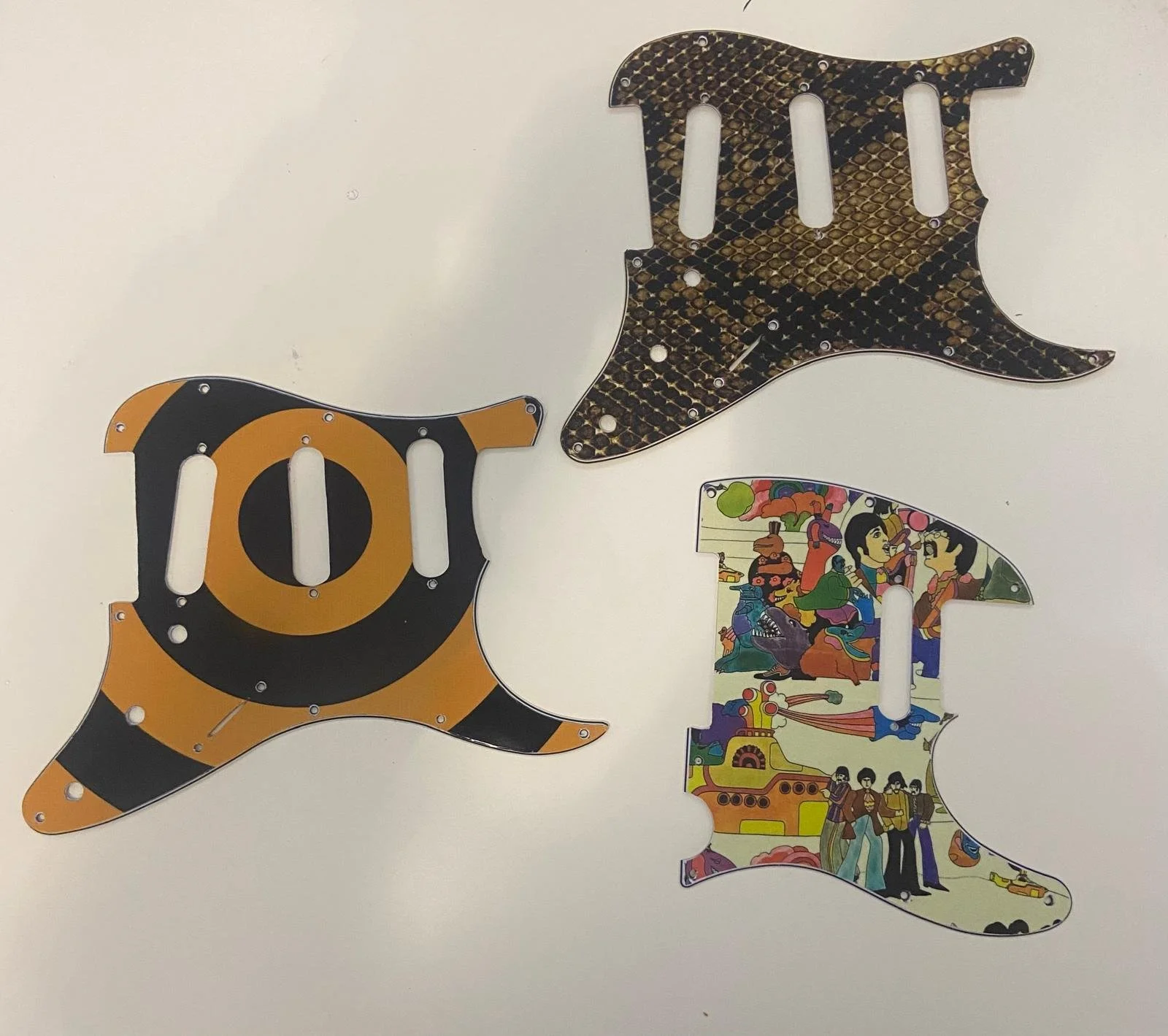 Three guitar-shaped cutouts with different colorful patterns on a white background.