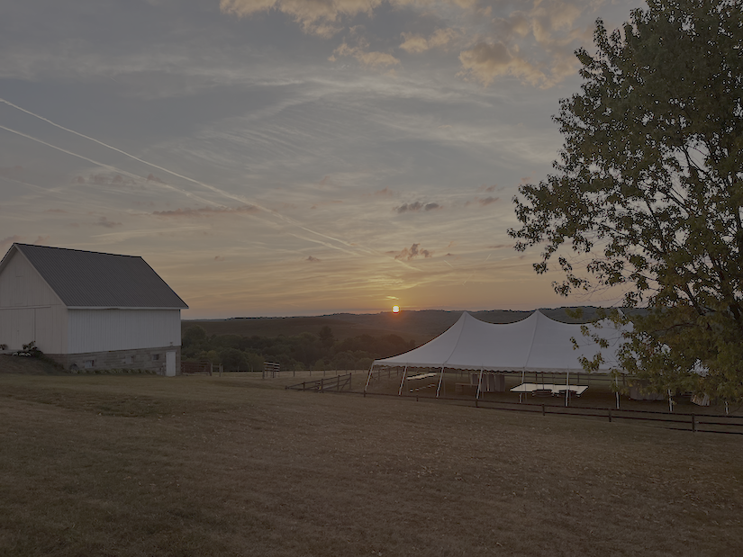 40x80 White High-Peak Tent with a White Barn Beside it at Sunset