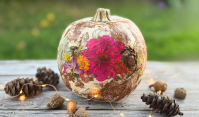 A faux pumpkin decoupaged with pressed flowers and patterned napkins
