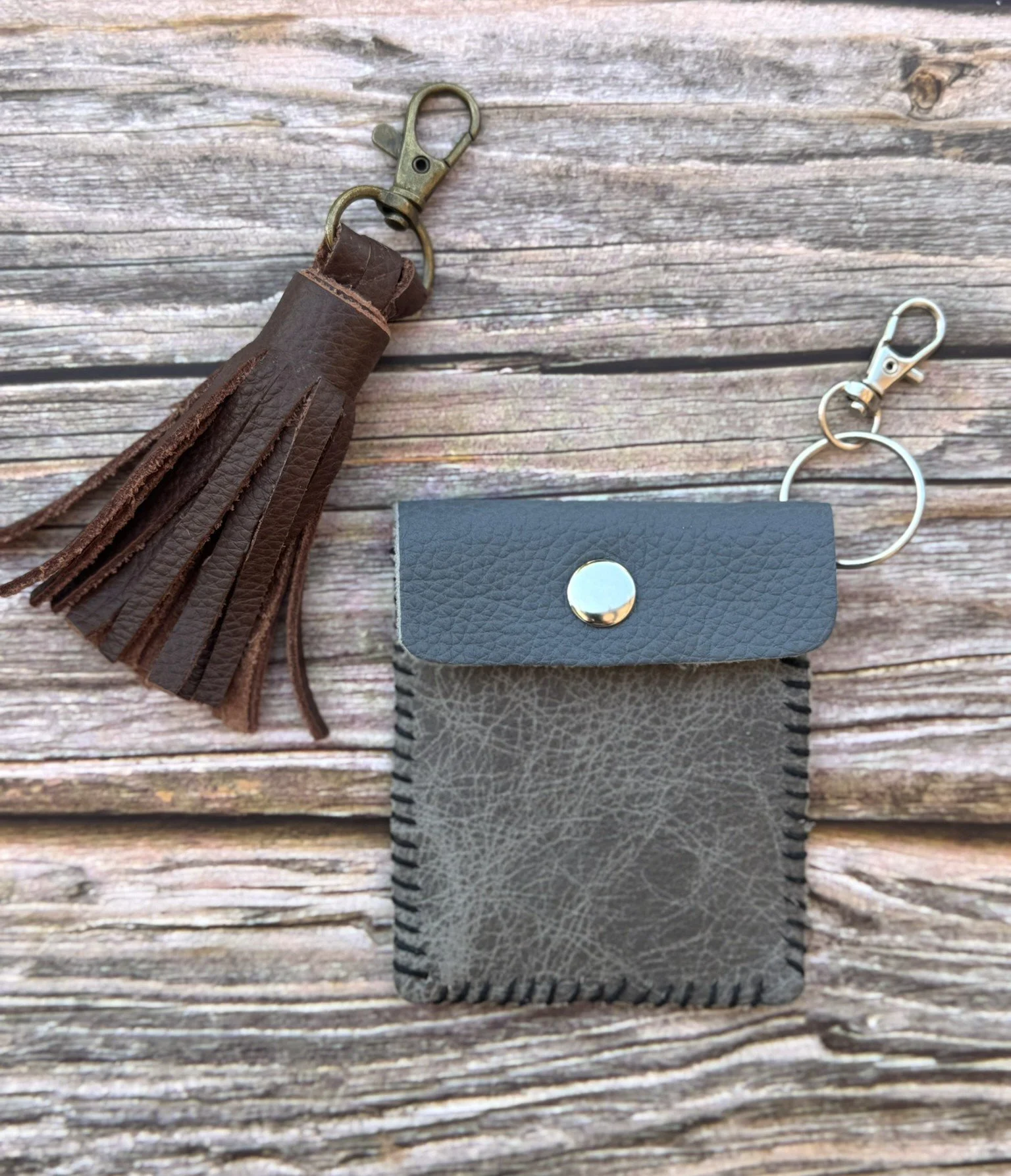 A leather tassel on a keychain and a small card-sized leather pouch.