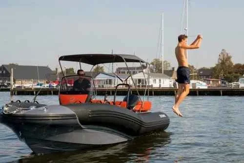 A member leaping off the boat for a swim on a sunny day