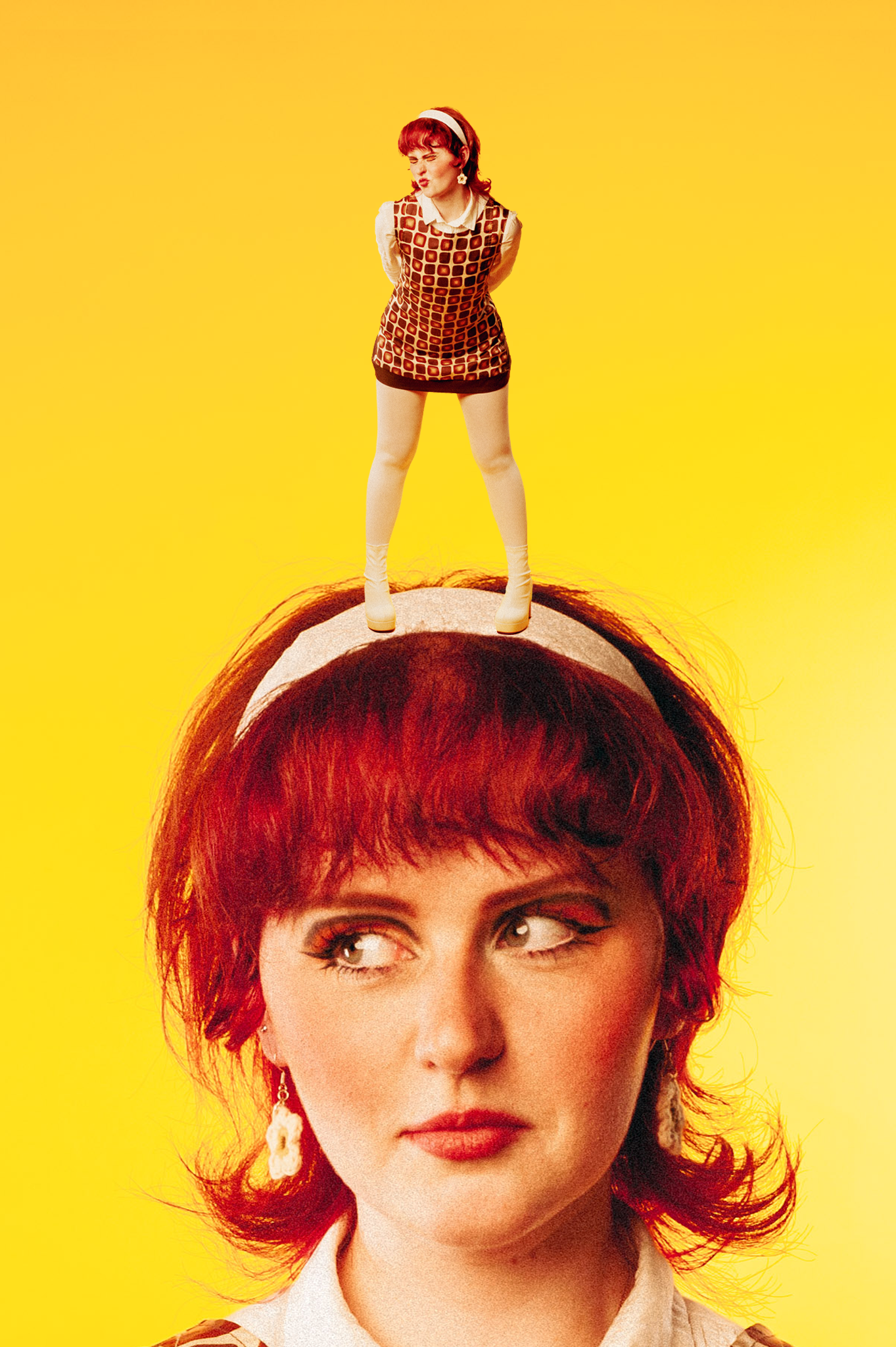 A woman with red hair and earrings looks to the side with a thoughtful expression, and a smaller woman with similar red hair, dressed in a retro outfit, is standing on top of her head against a yellow background.