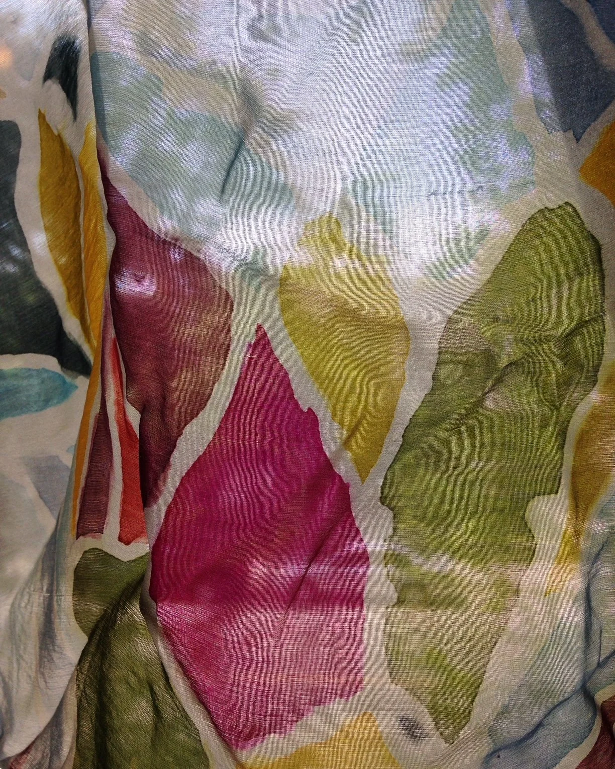 Silk painting with light shining from behind. Stained glass pattern in pinks, greens, and yellows.