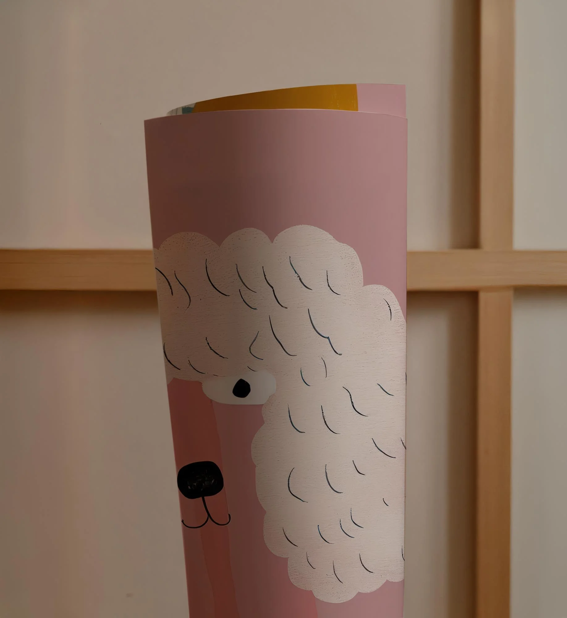 Pink paper cup with a cartoon illustration of a white poodle's face and curly fur, set against a wooden grid background.