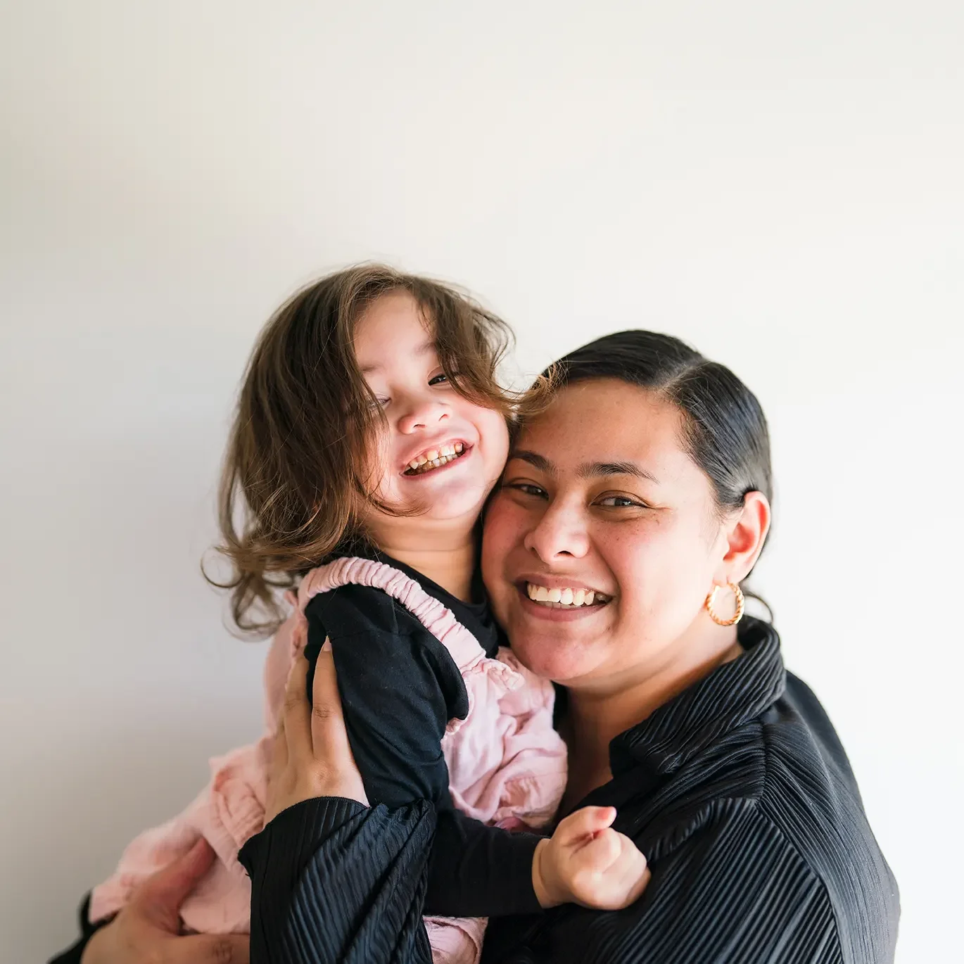 Māmā and her tamariki smiling