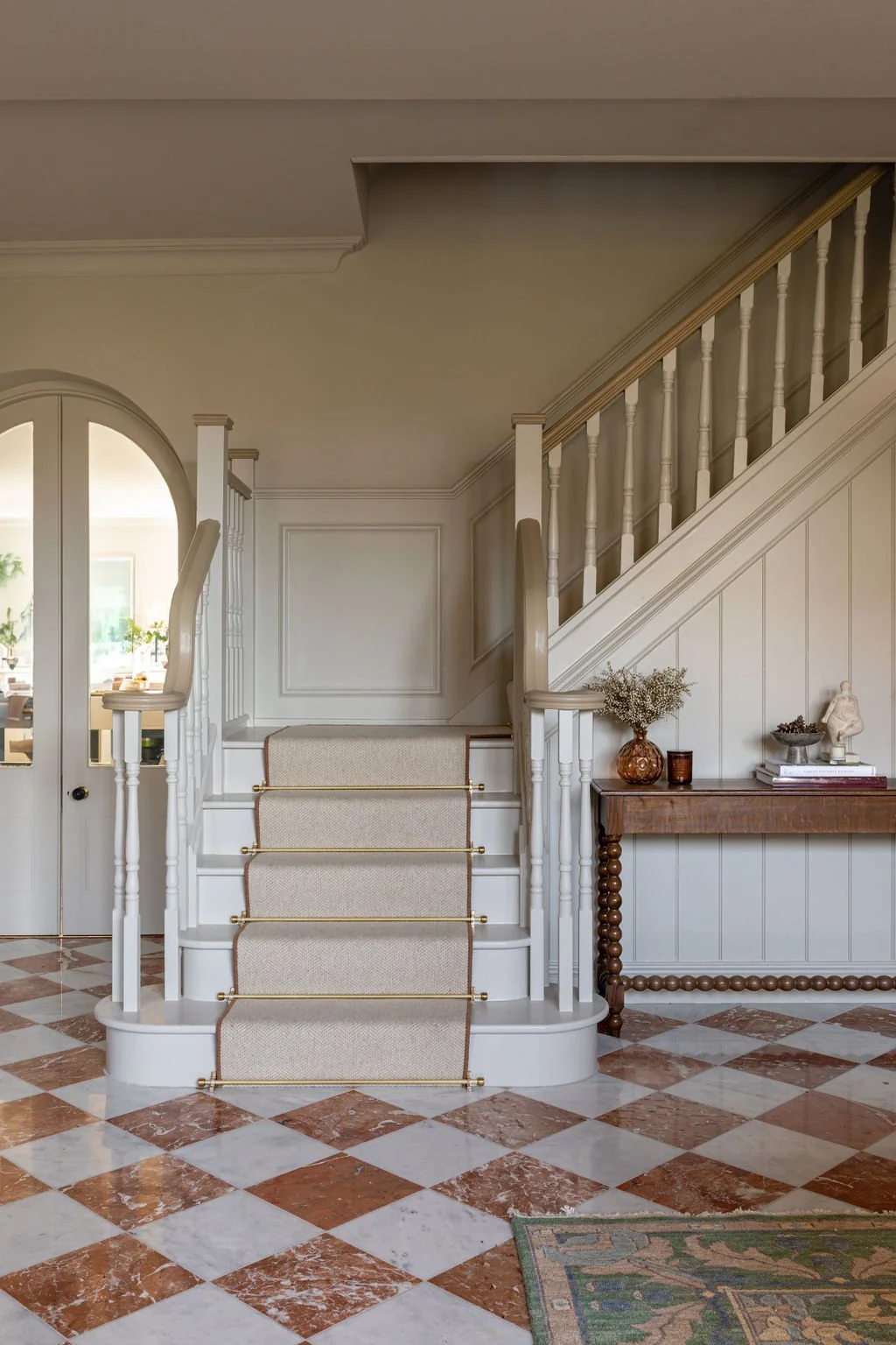 Grand entrance hall chequerboard marble floor stairs runner brass rods