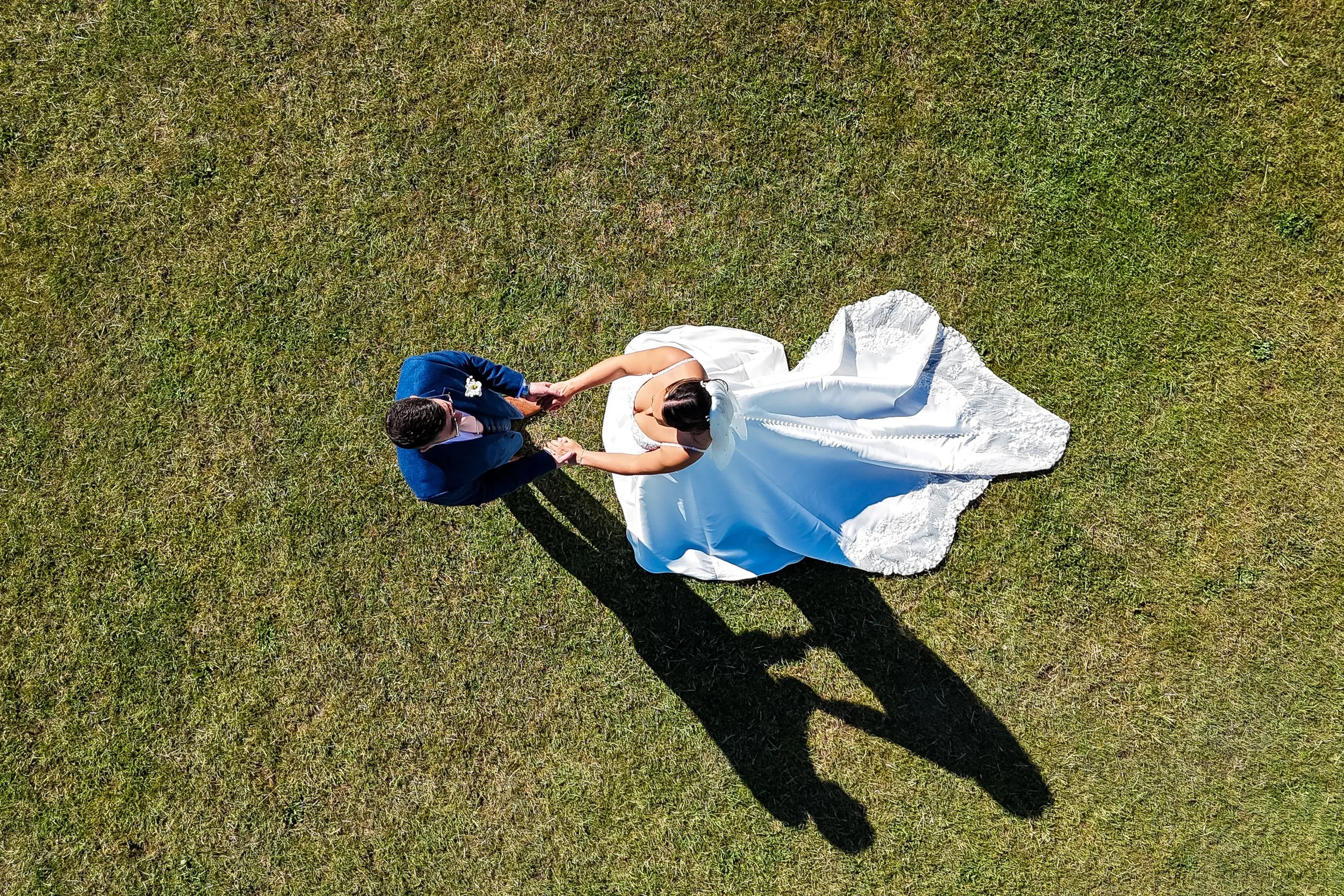 Wedding drone photograph of bride and groom holding hands