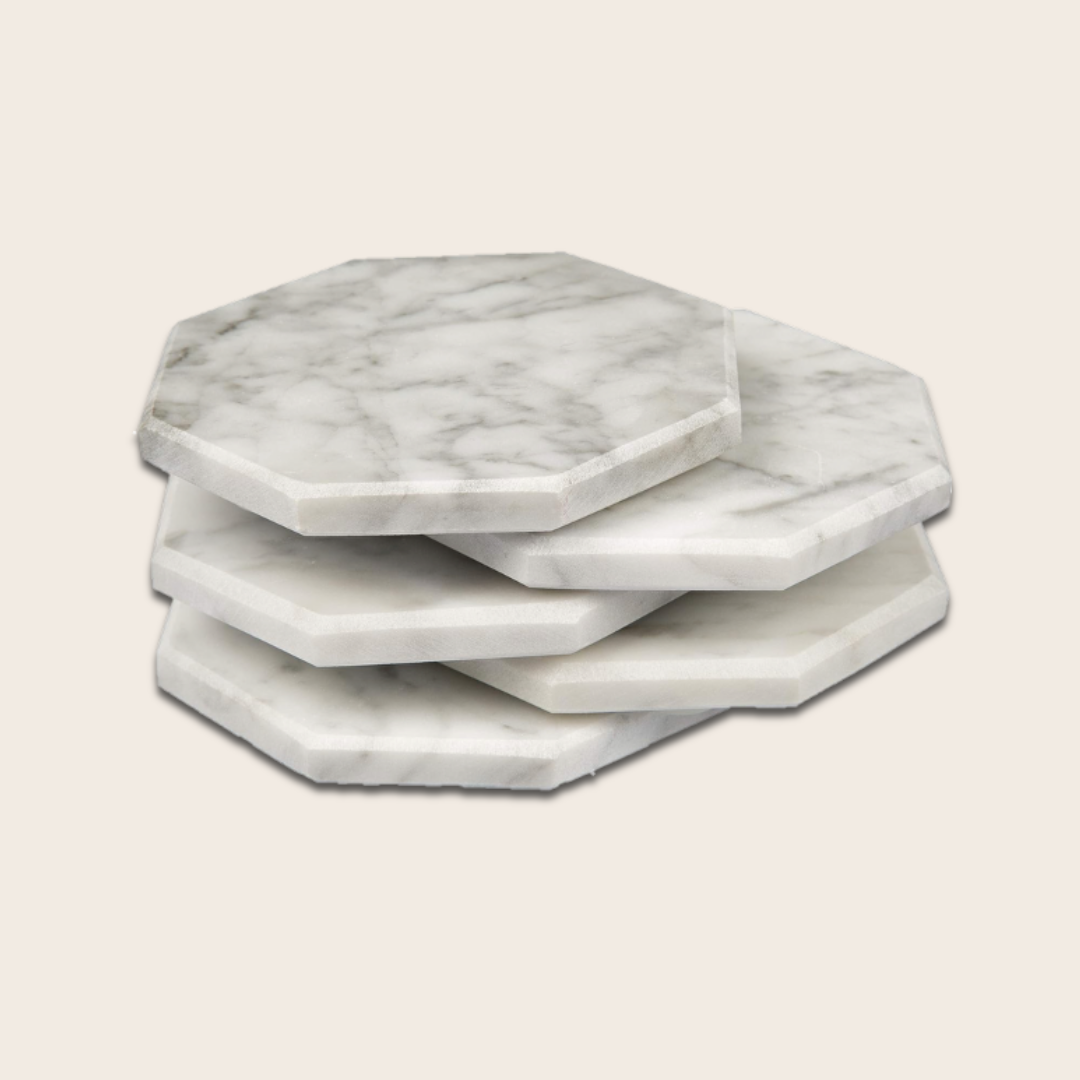 Stack of four hexagonal marble coasters on a white background.