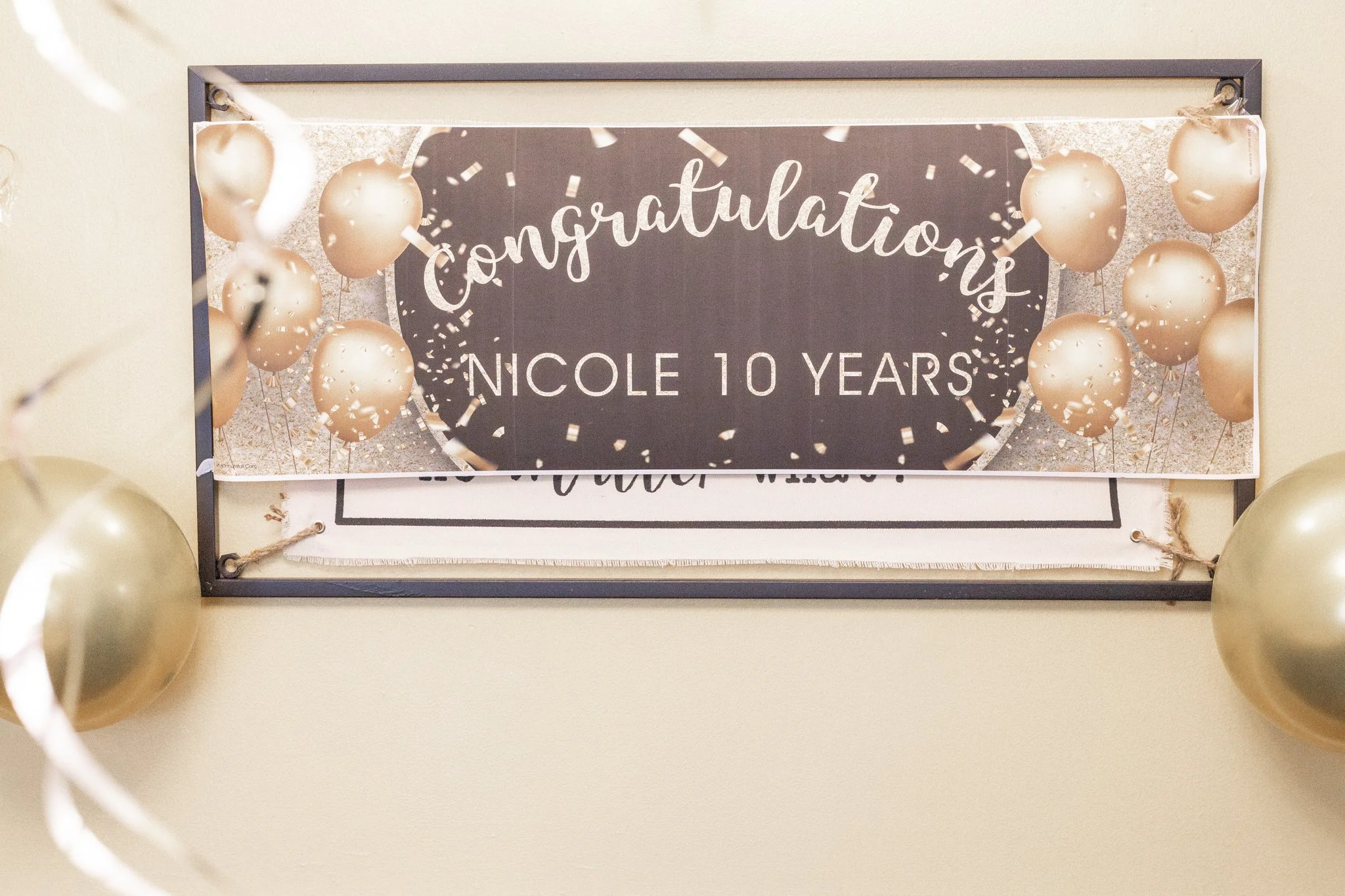 Celebration sign with gold balloons and confetti for Nicole's 10th birthday.