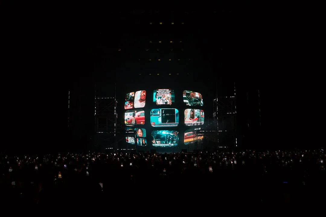 Concert stage with large screen displaying various images and videos.