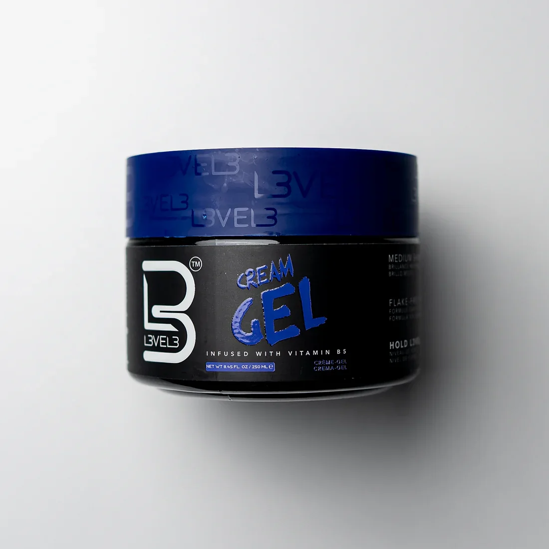 A black container of L3VEL3 cream gel hair styling product with a blue lid, on a white background.