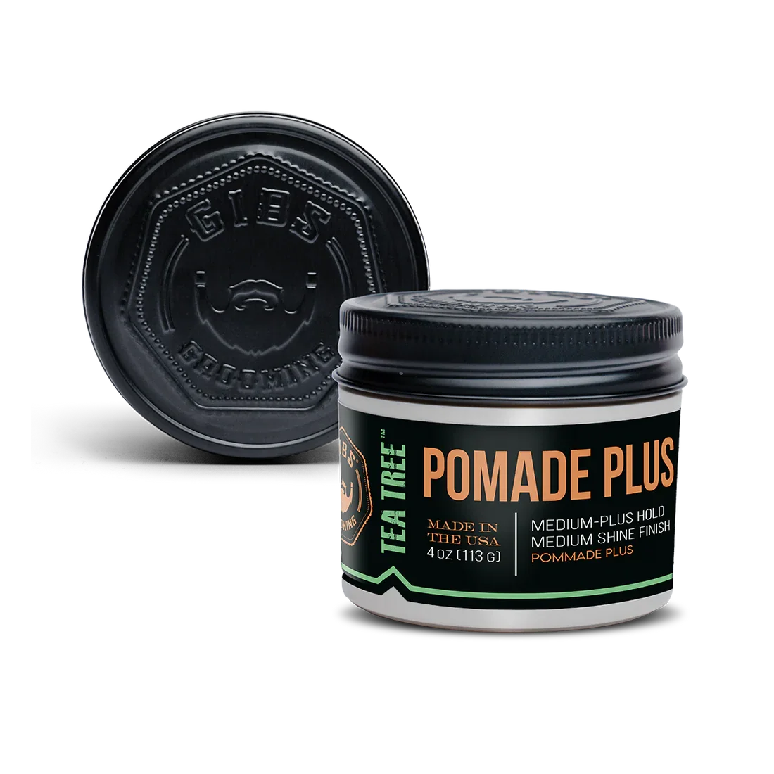 A black container of Tea Tree Pomade Plus hair styling product with a black lid and a logo on top, placed on a black background.