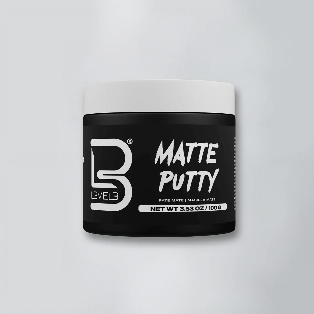 A black container of Level Matte Putty on a light background.