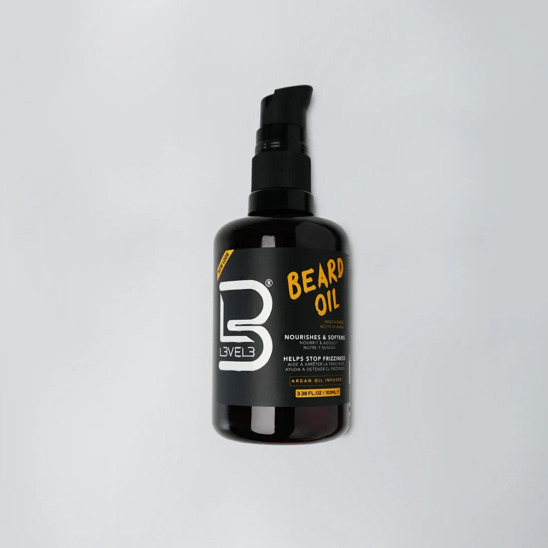 Black bottle of beard oil with a pump dispenser, label reads 'Beard Oil', helps stop frizz, contains argan oil, 3.38 fl oz, on a light background.