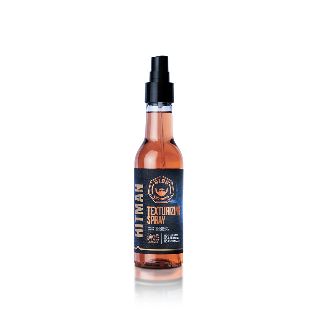 A bottle of Hulkman texturizing spray with black and orange label, placed on a reflective surface against a light background.