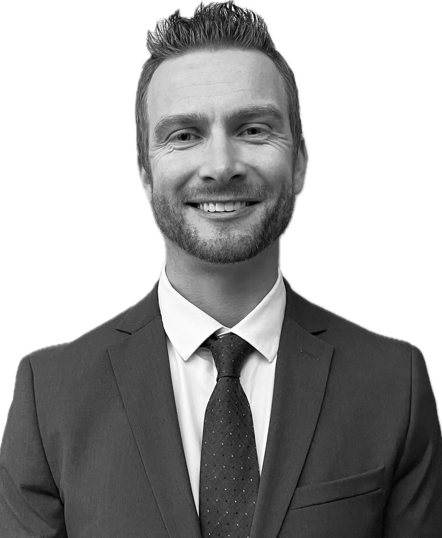 Black and white portrait of a smiling man wearing a formal suit, white shirt, and tie.