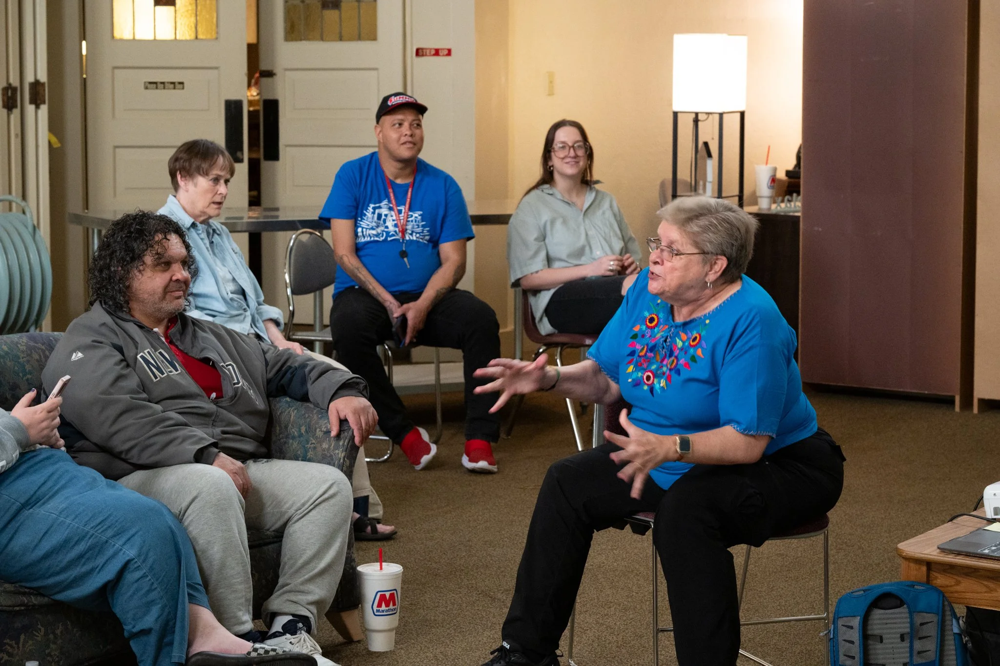 Recovery Cafe Muncie volunteer Deb, right, presents information about her recent trip to Guatemala to the guests at the cafe April 3 in Muncie, Indiana. Deb is a retiree and spends much of her free time traveling. When she returns, she presents her t