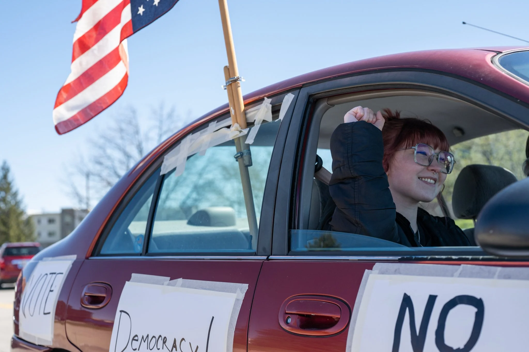 A protester drives past in a decorated car during the ‘No Kings 3’ protest March 28 at the Fallen Heroes Memorial Bridge. 