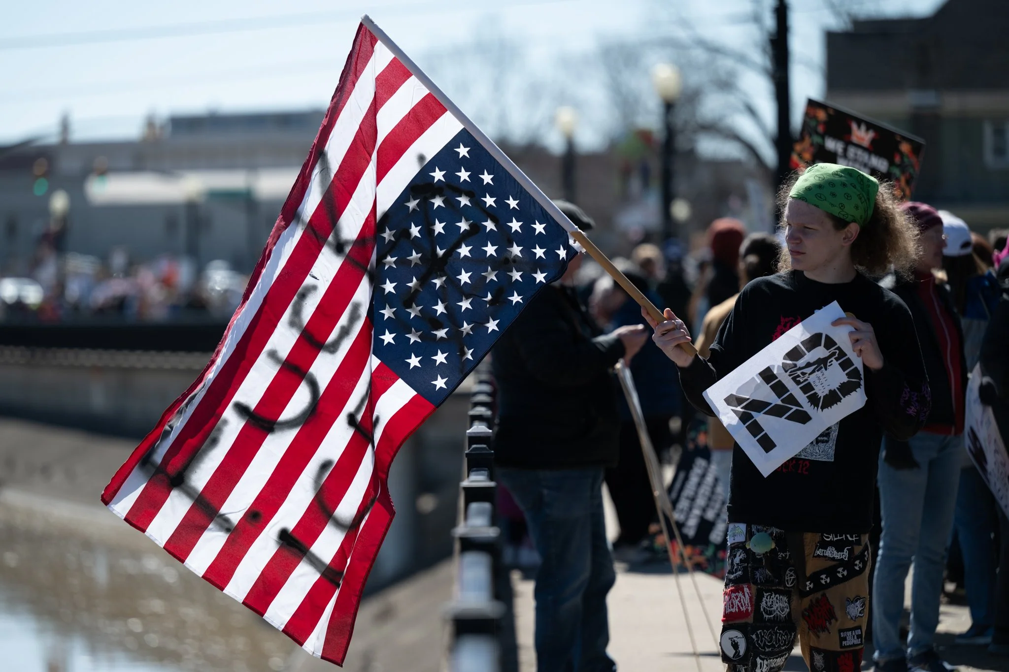 A protester waves an upside-down American Flag with the words ‘Fuck ICE’ inscribed during the ‘No Kings 3’ protest March 28 at the Fallen Heroes Memorial Bridge.