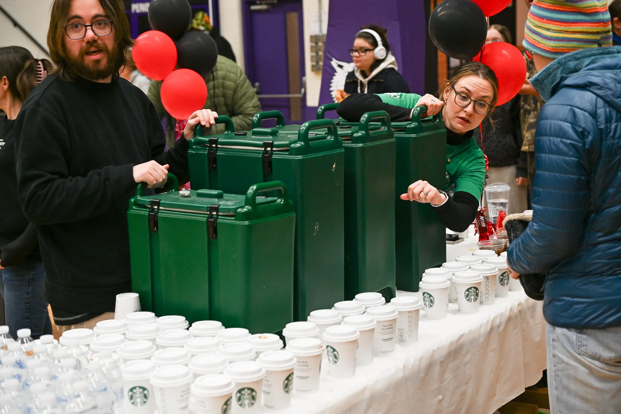 A worker of the Muncie Mission Walk a Mile in My Shoes event assists an attendee Feb. 21 in the Muncie Fieldhouse. 