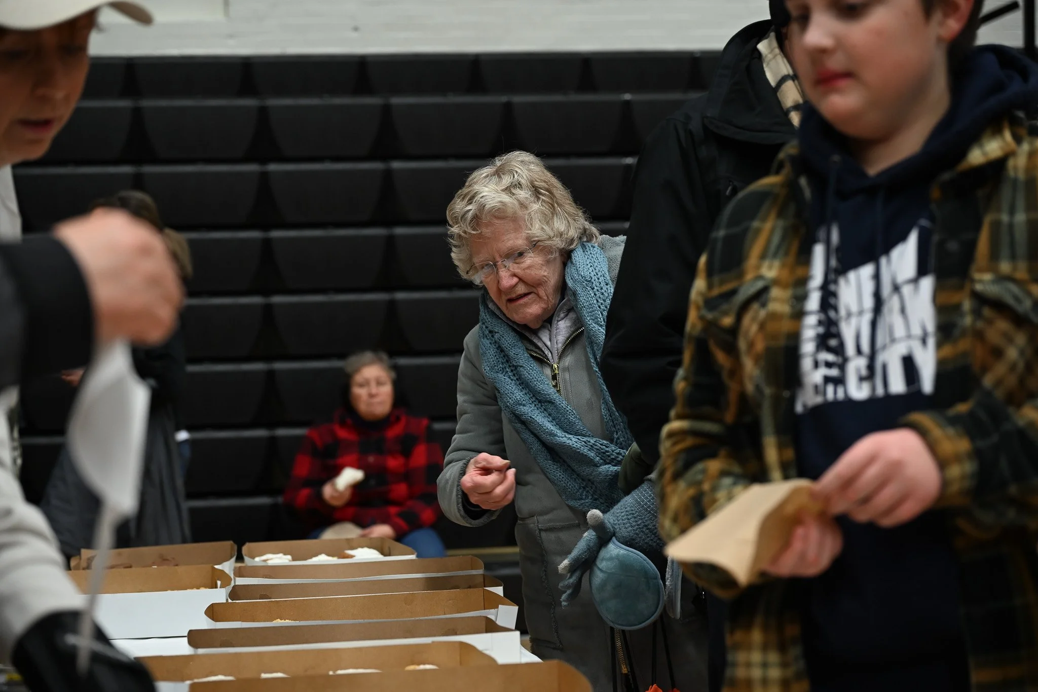 An attendee of Muncie Mission's Walk a Mile in My Shoes event browses donuts before the event starts Feb. 21 in the Muncie Fieldhouse. 