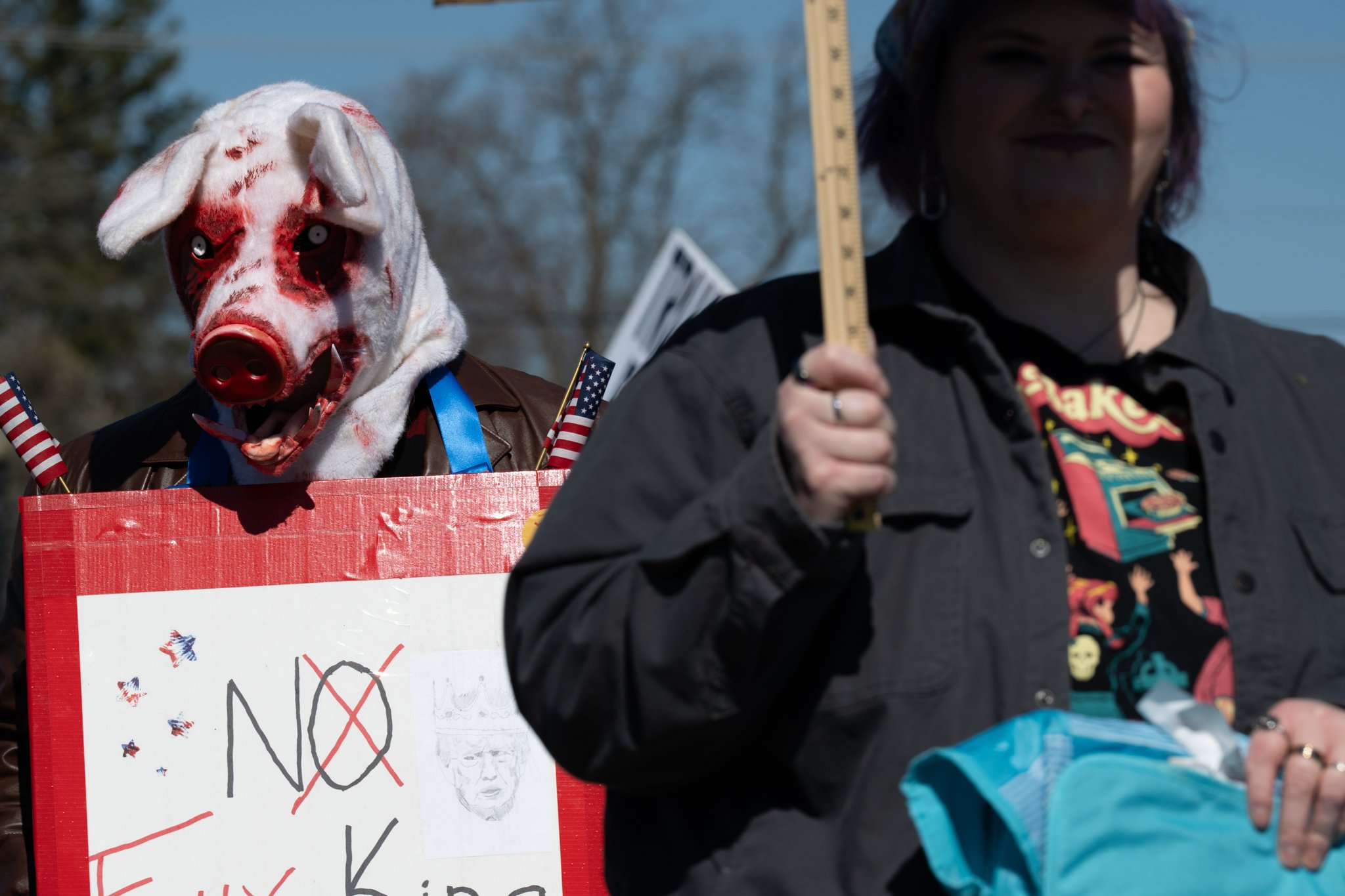 A protester wearing a bloody pig costume marches during the ‘No Kings 3’ protest March 28 at the Fallen Heroes Memorial Bridge. 