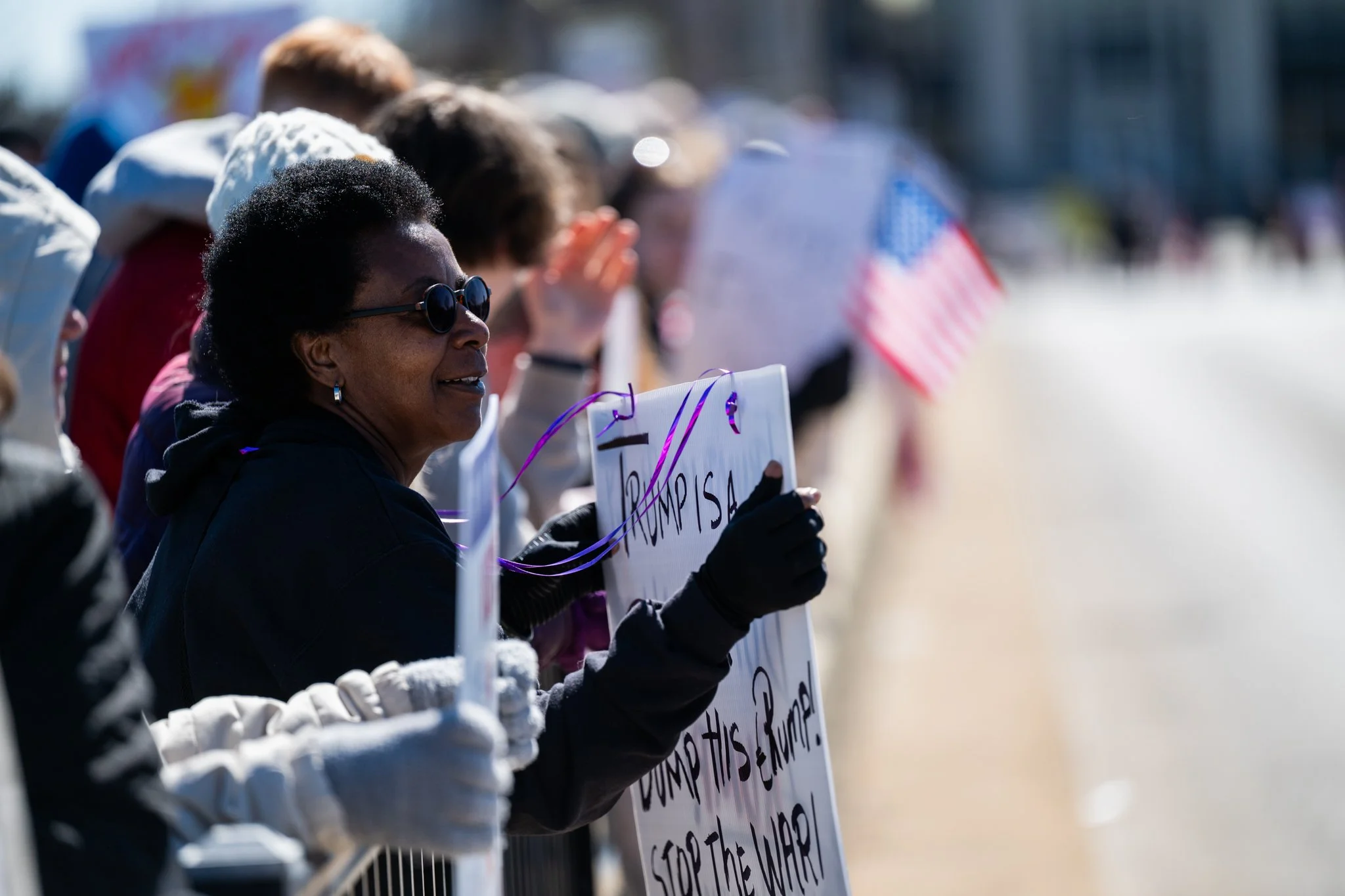 A protester leans along the railing of the Fallen Heroes Memorial Bridge during the ‘No Kings 3’ protest March 28 in downtown Muncie.