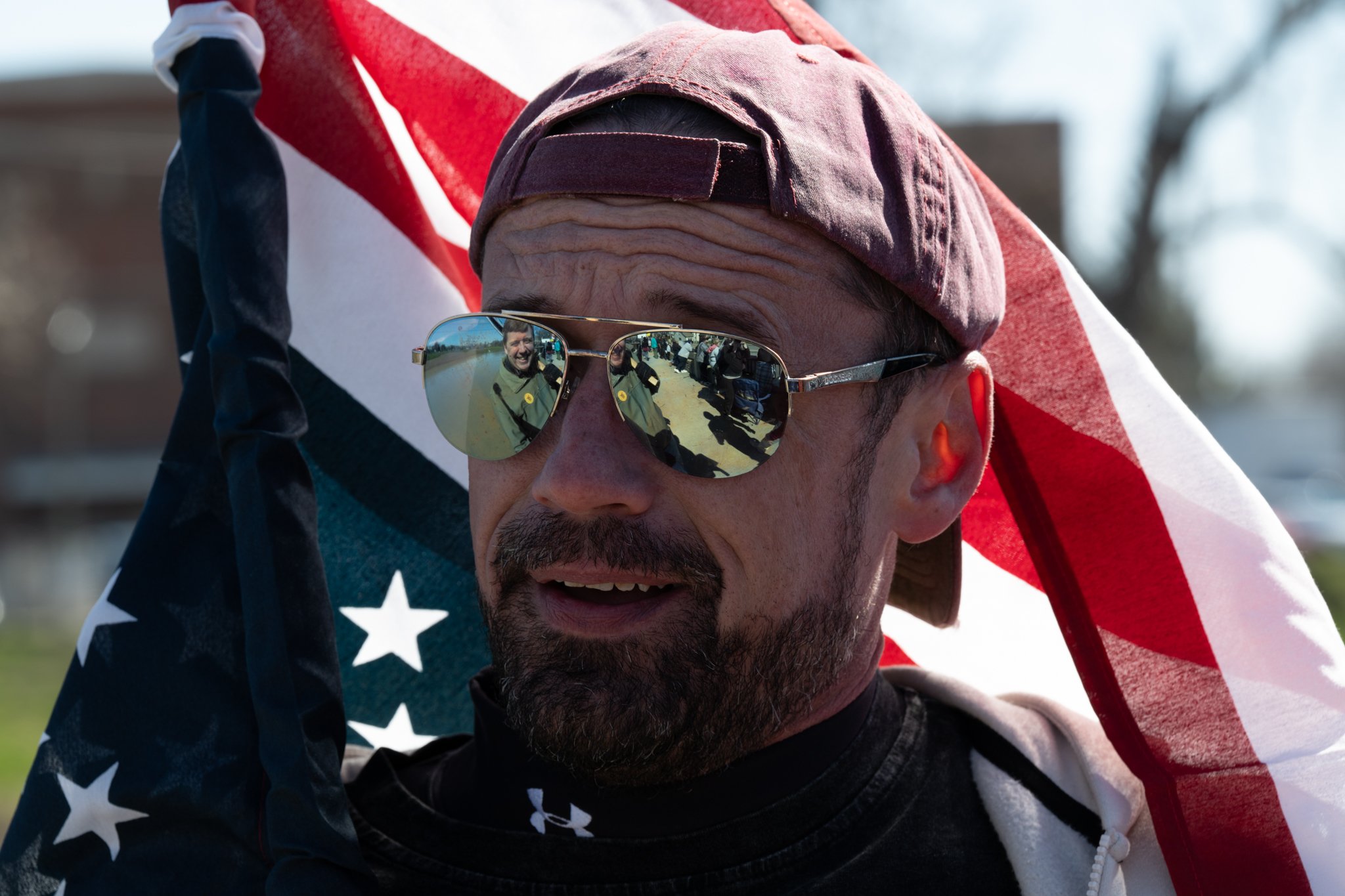 A protester waves an American flag during the ‘No Kings 3’ protest March 28 at the Fallen Heroes Memorial Bridge.