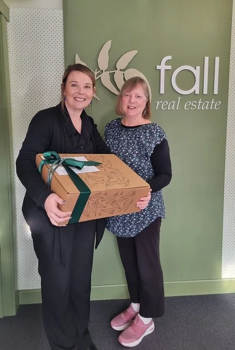 Kaylie from Falls Real Estate receiving a hamper donated by Tasmanian Occasion Hampers for the Kids Cancer Project Charity Gala at Hotel Grand Chancellor