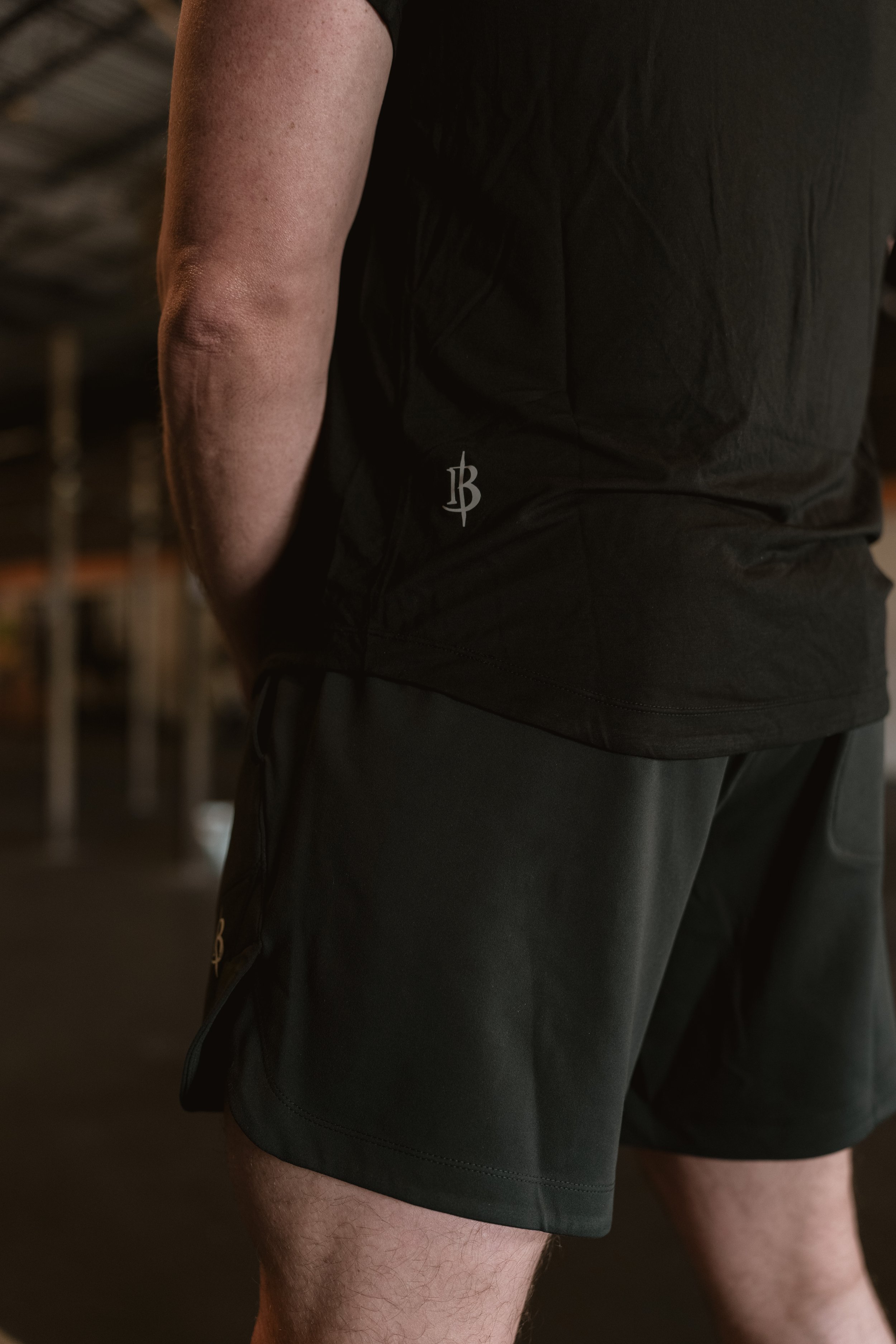 Iron + Bone Resurgence Short back view — IB monogram branding on men's black performance training shorts