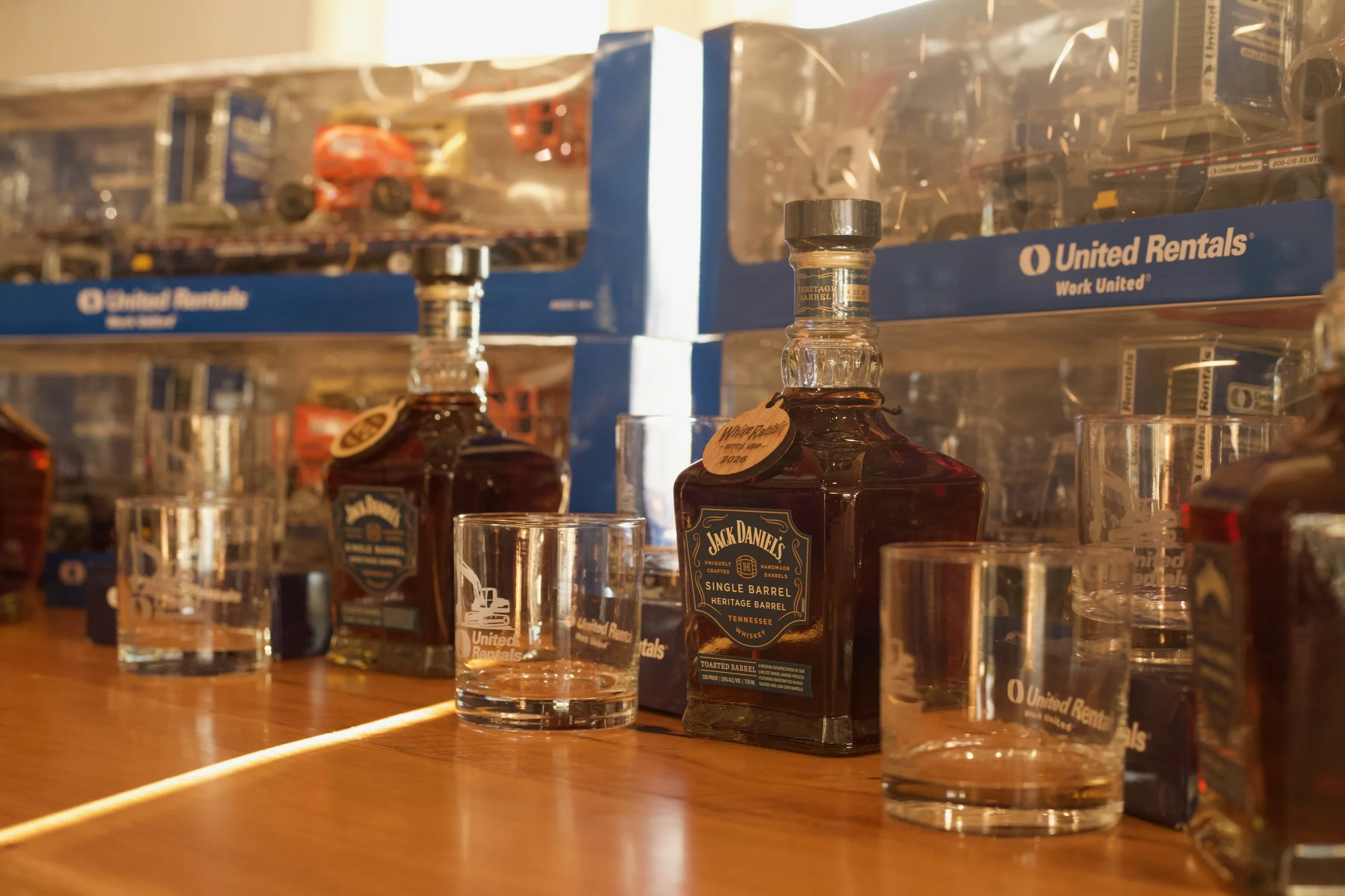 Display of miniature cars in clear plastic cases on a shelf in a store.