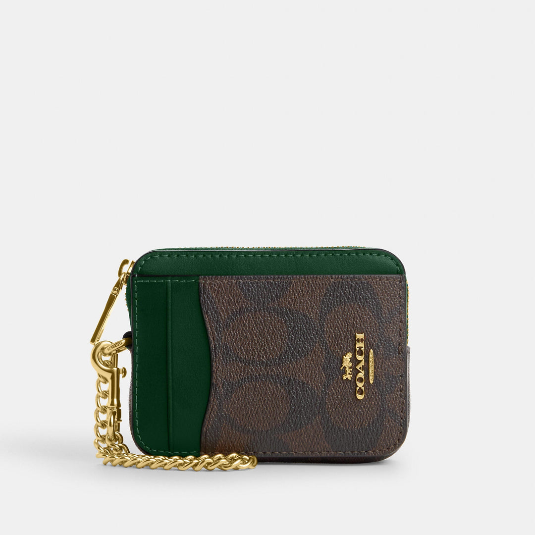 Green and brown Coach card case with gold chain and logo on white background.