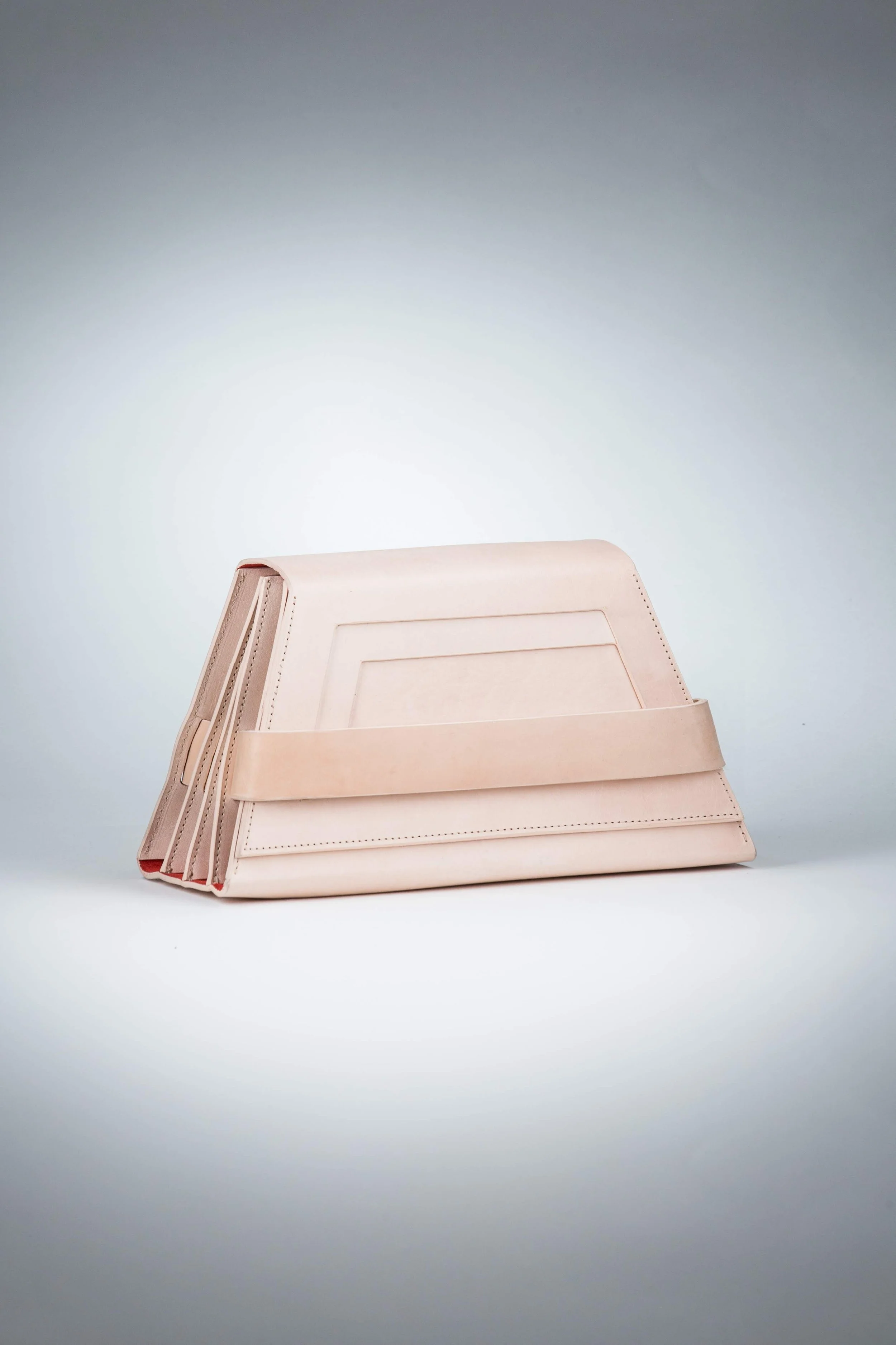 Beige leather handbag with a structured design and front strap