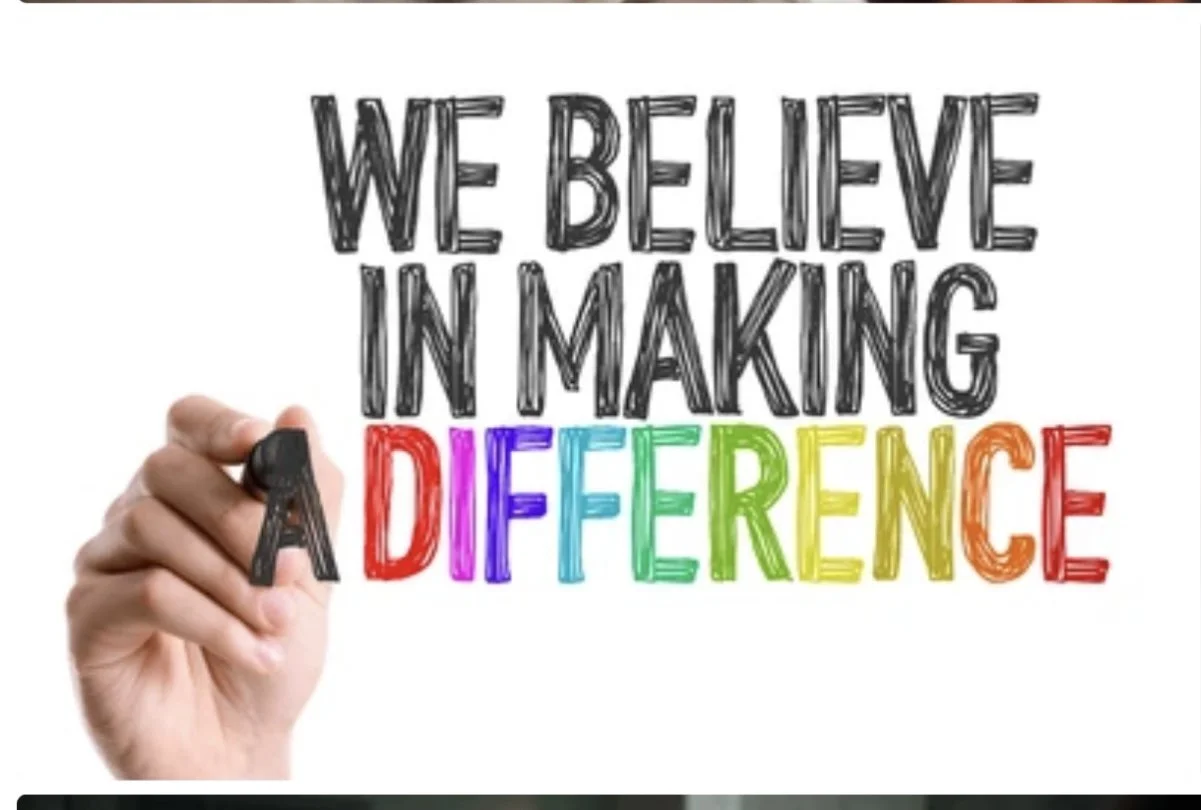 Hand holding a black marker writing the phrase "We believe in making a difference" with the word "difference" in rainbow colors.