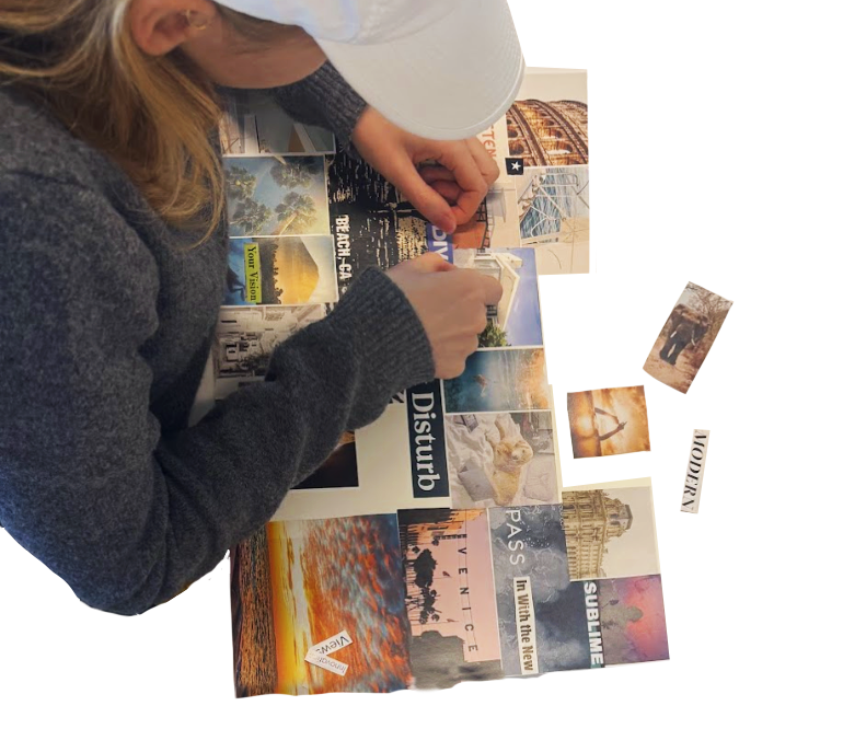 A person in a therapeutic arts workshop in California, with blonde hair, wearing a white cap and a gray long-sleeve shirt, arranging travel postcards and photos on a table.