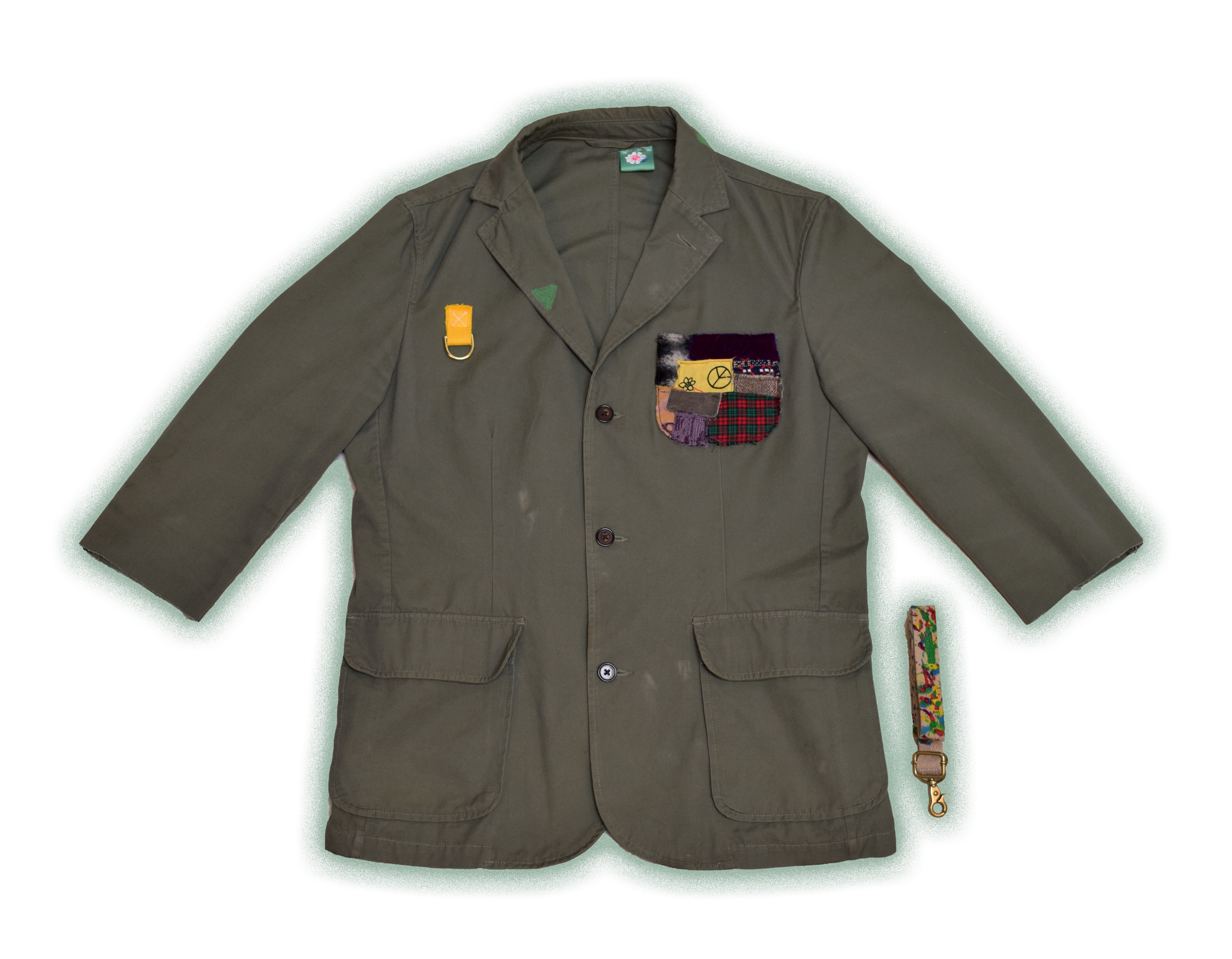 A greenish-brown jacket with colorful patches on the chest pocket and a small zipper pull on the left shoulder.