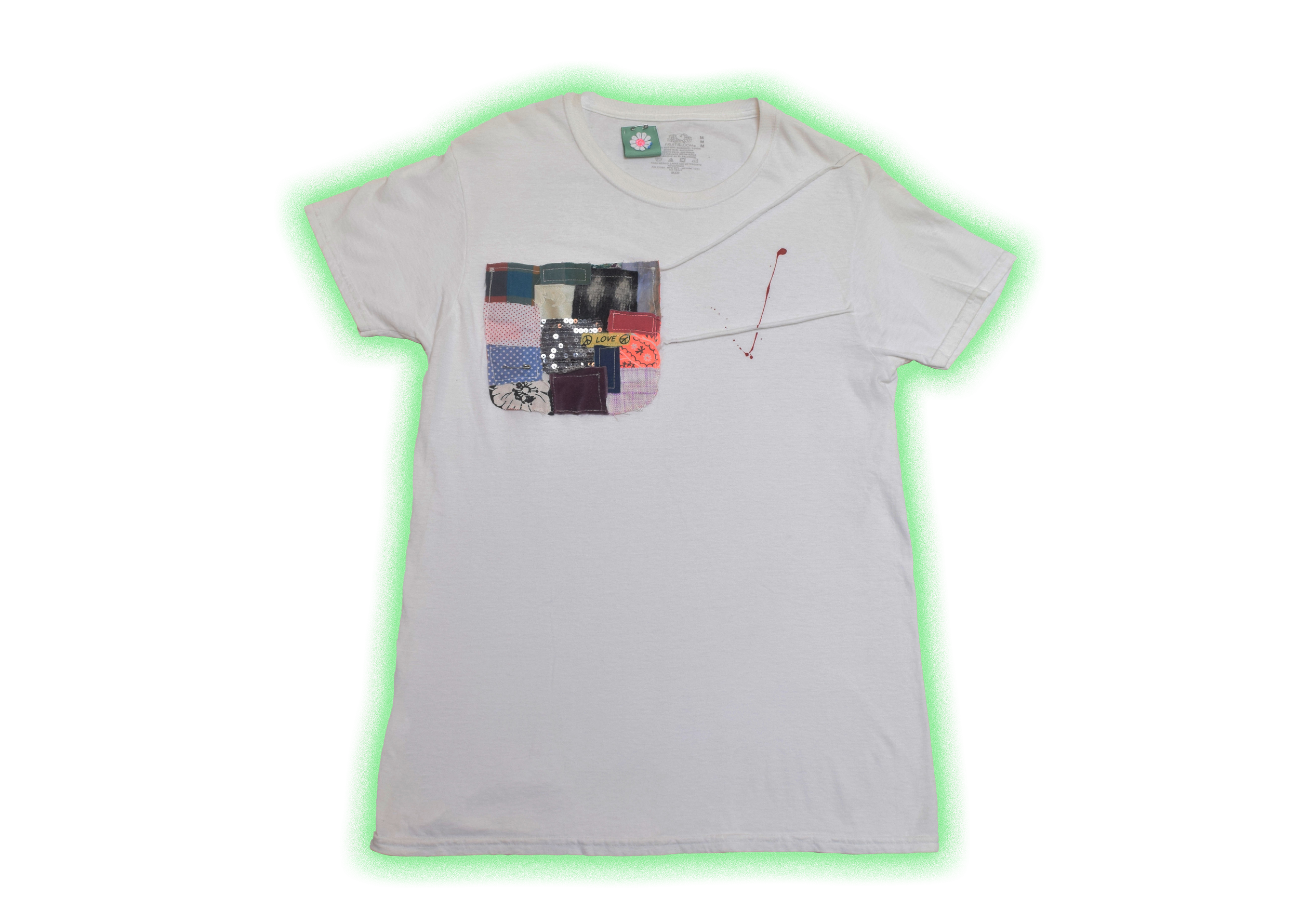 White T-shirt with a multicolored patchwork design on the left chest area, a small black and red square, and a red paint splatter near the shoulder.