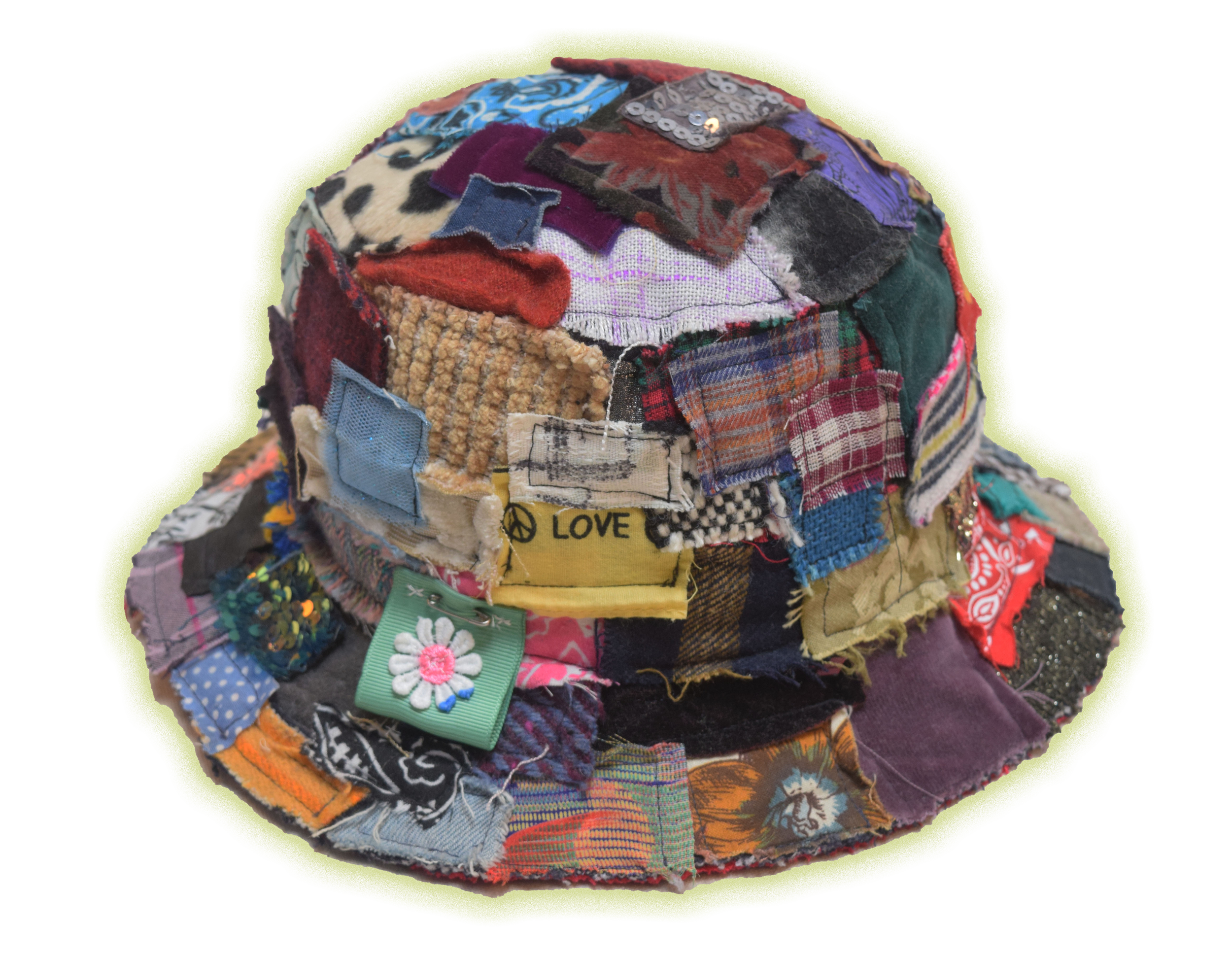 A colorful, patchwork hat made from various fabric pieces including patches, patches with embroidered designs, and text, creating a textured and whimsical appearance.