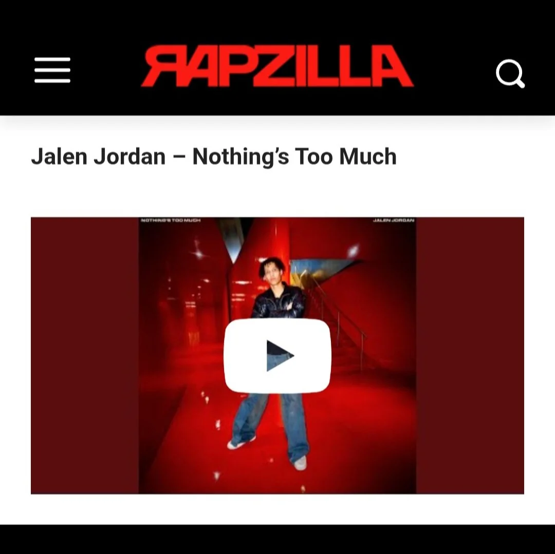 Rapzilla website featuring Jalen Jordan's song 'Nothing's Too Much'. The image shows a person standing indoors in front of a red wall, wearing a black jacket and blue jeans, with a large white play button overlay in the center.