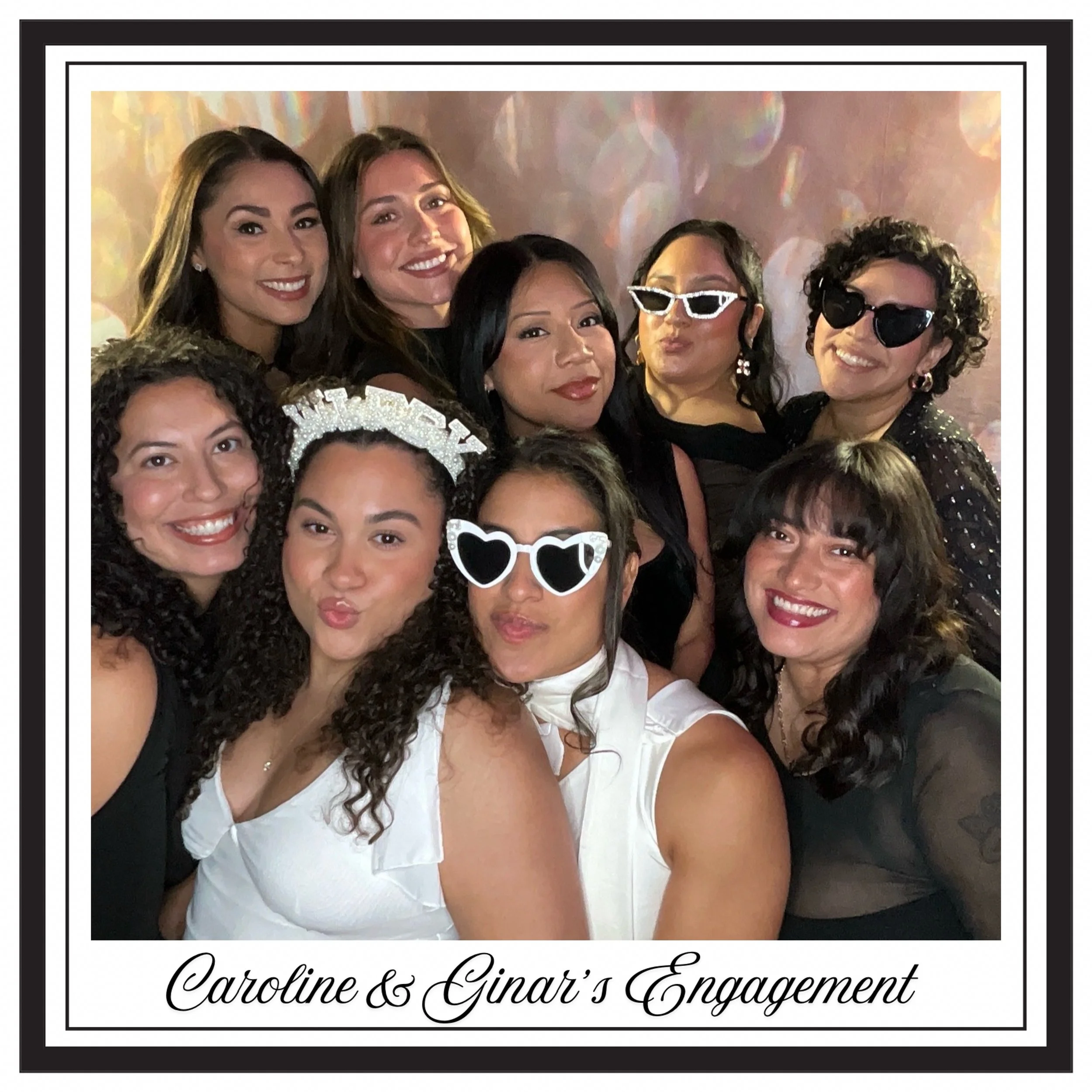 Group of women celebrating Caroline and Ginat's engagement, wearing party accessories, smiling and making playful gestures.