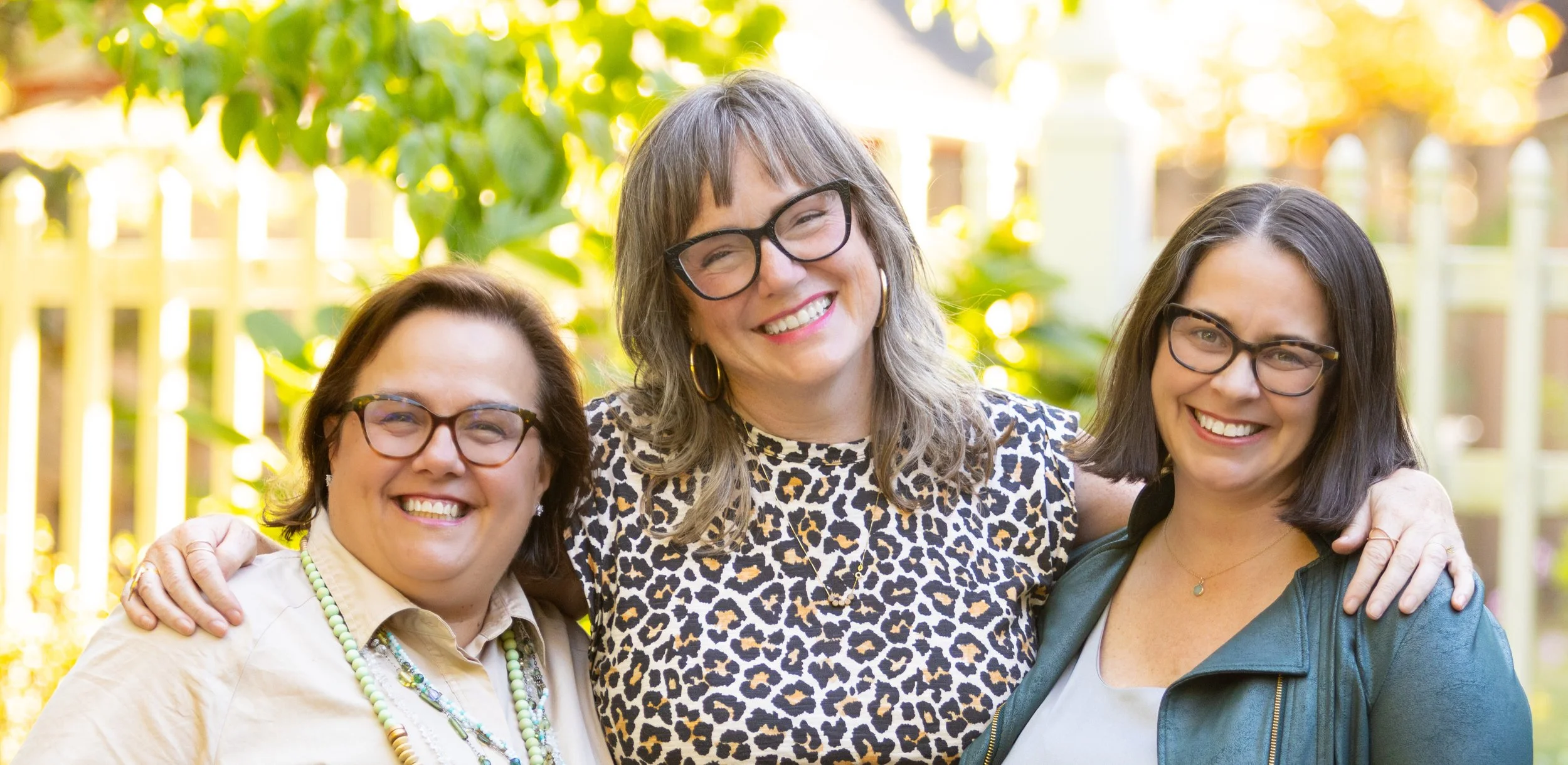 Group of three female founders of liveable Homes all wearing glasses and smiling broadly.