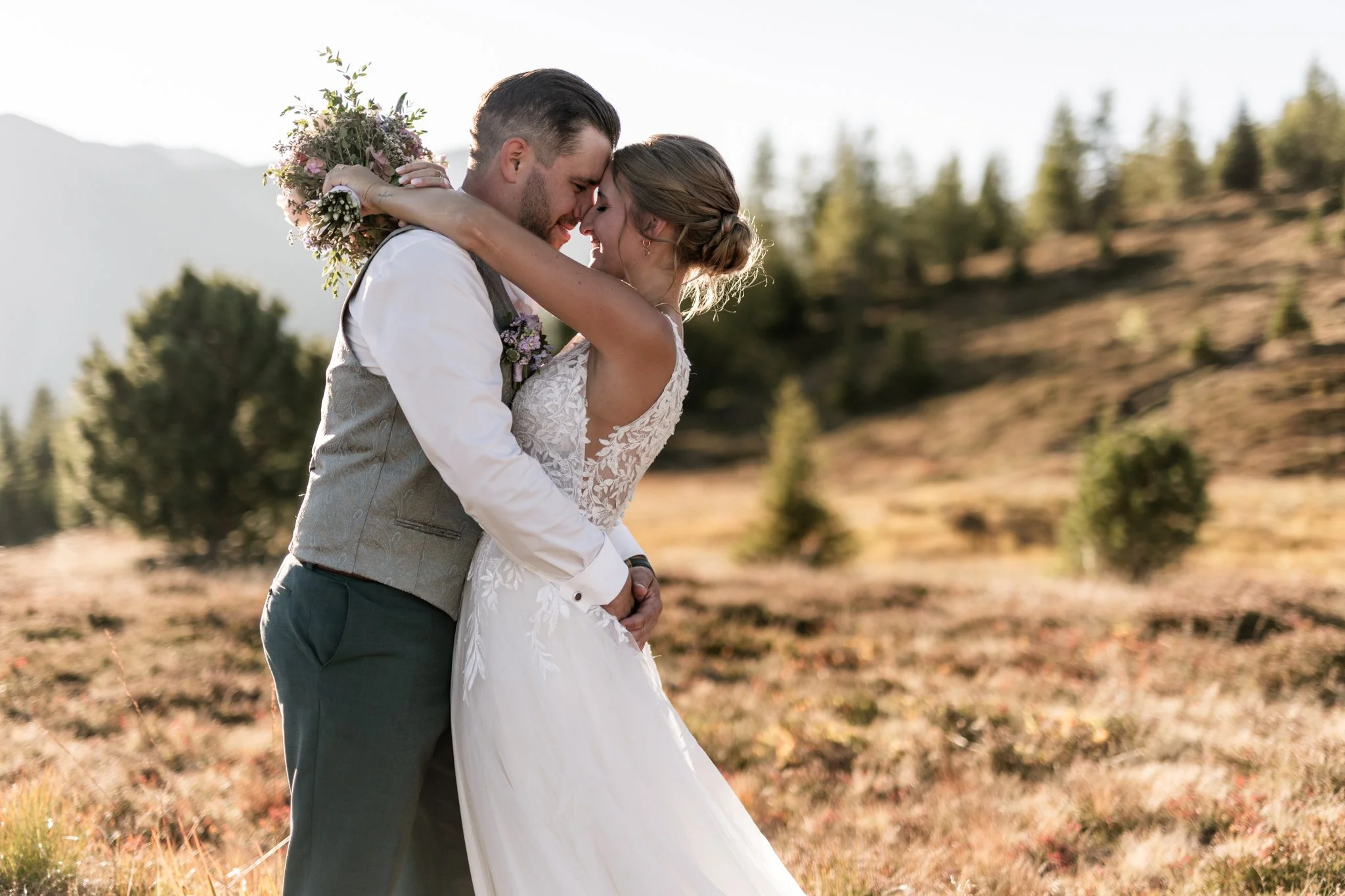 Braut legt ihre Arme über die Schultern des Bräutigams 