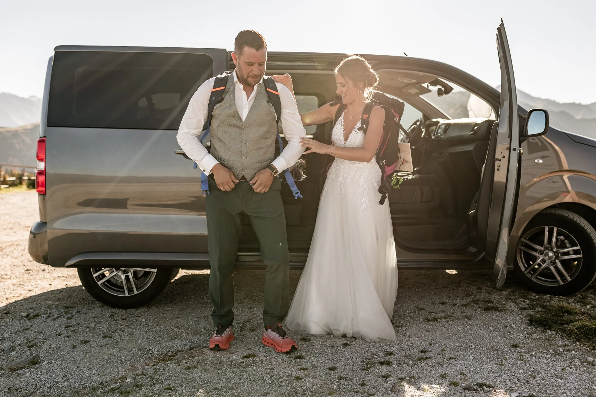 Brautpaar hilft sich Gegenseitig beim Anziehen für den kurzen Gang zur Shootinglocation 