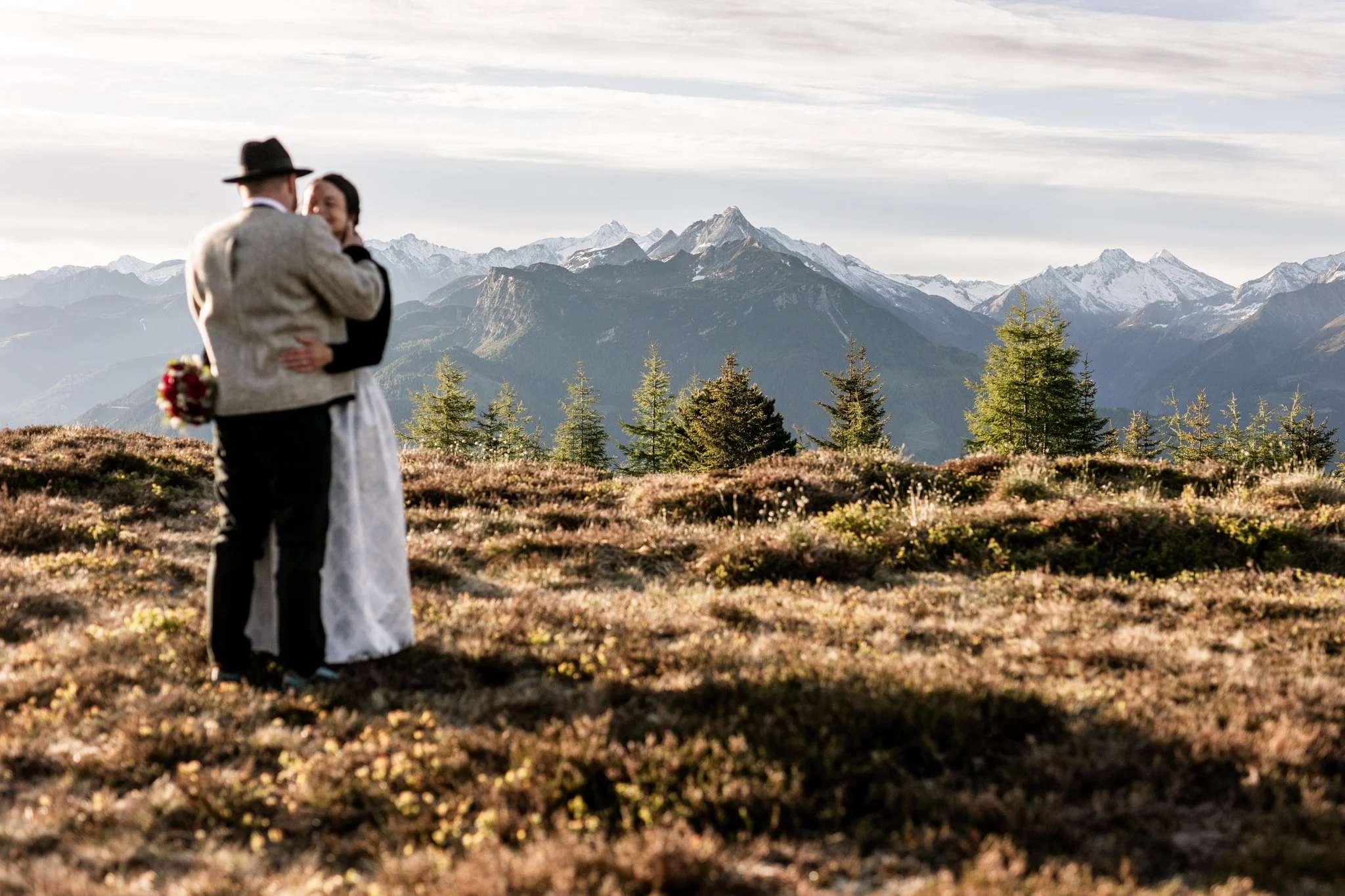 Mann und Frau auf einem Almboden im hinteren Zillertal in Tirol bei einem authentischem Hochzeitsfotoshooting. 
